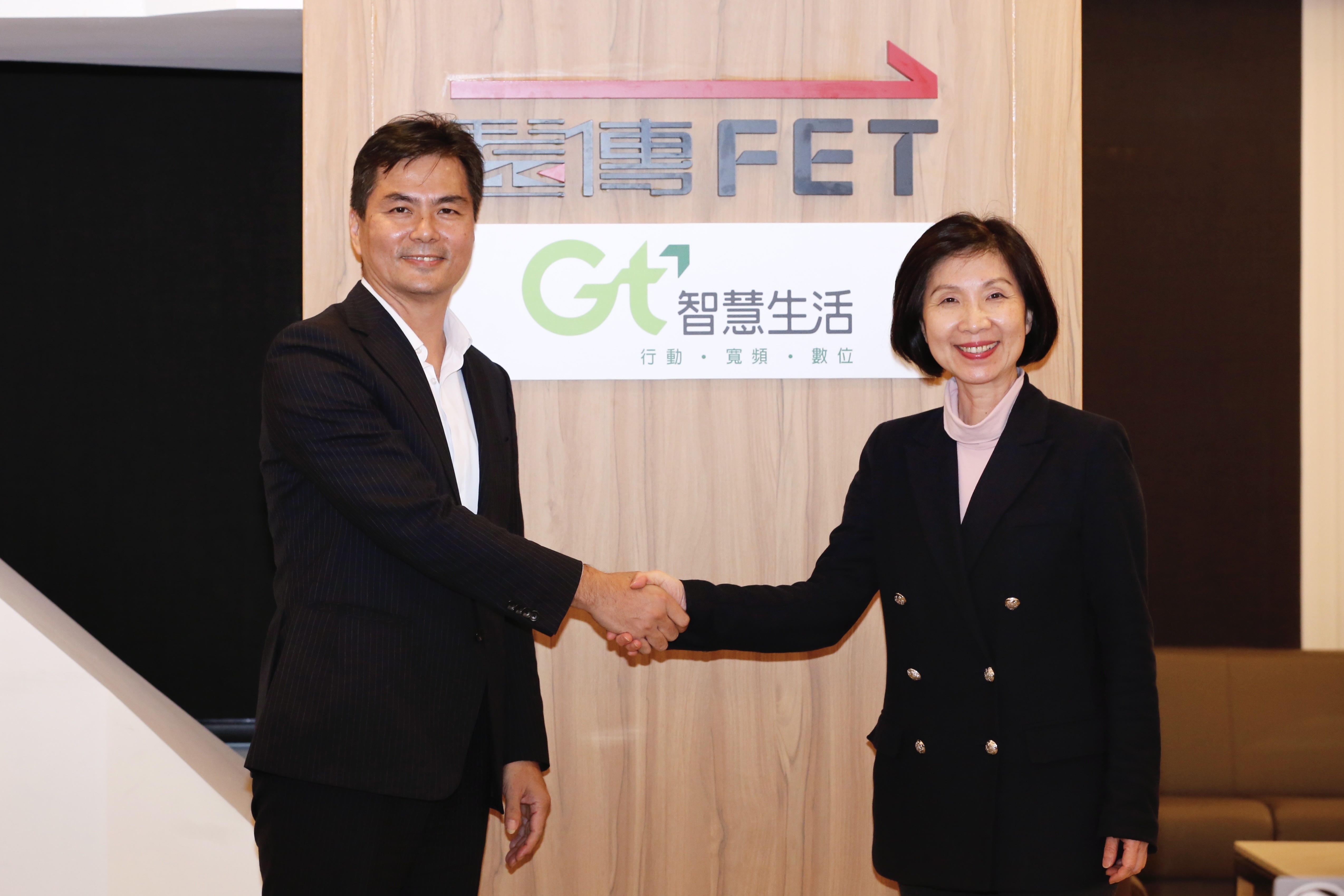 遠傳總經理井琪（右）和亞太電信董事長陳鵬（左）宣布2公司合併。