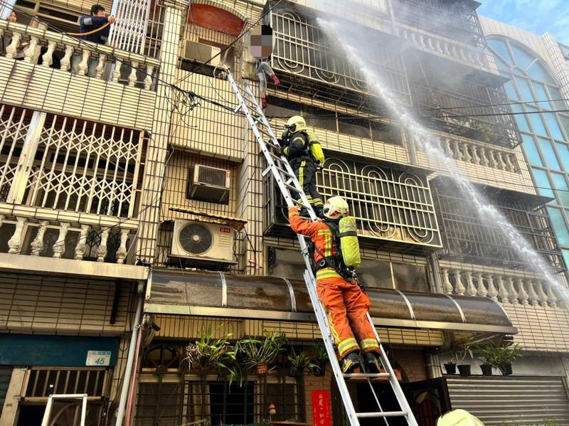 桃園市平鎮區民宅大火，楊姓婦人難耐濃煙嗆人，差點跳樓逃生，消防員緊急架設雙節梯，將婦人救出。（消防局提供）