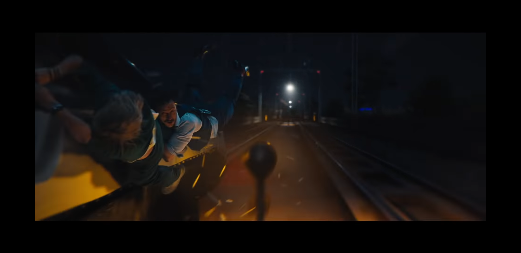 亞倫強森與小布一起掛在子彈列車門邊，對向列車也正駛來，情勢千鈞一髮。（翻攝自預告）