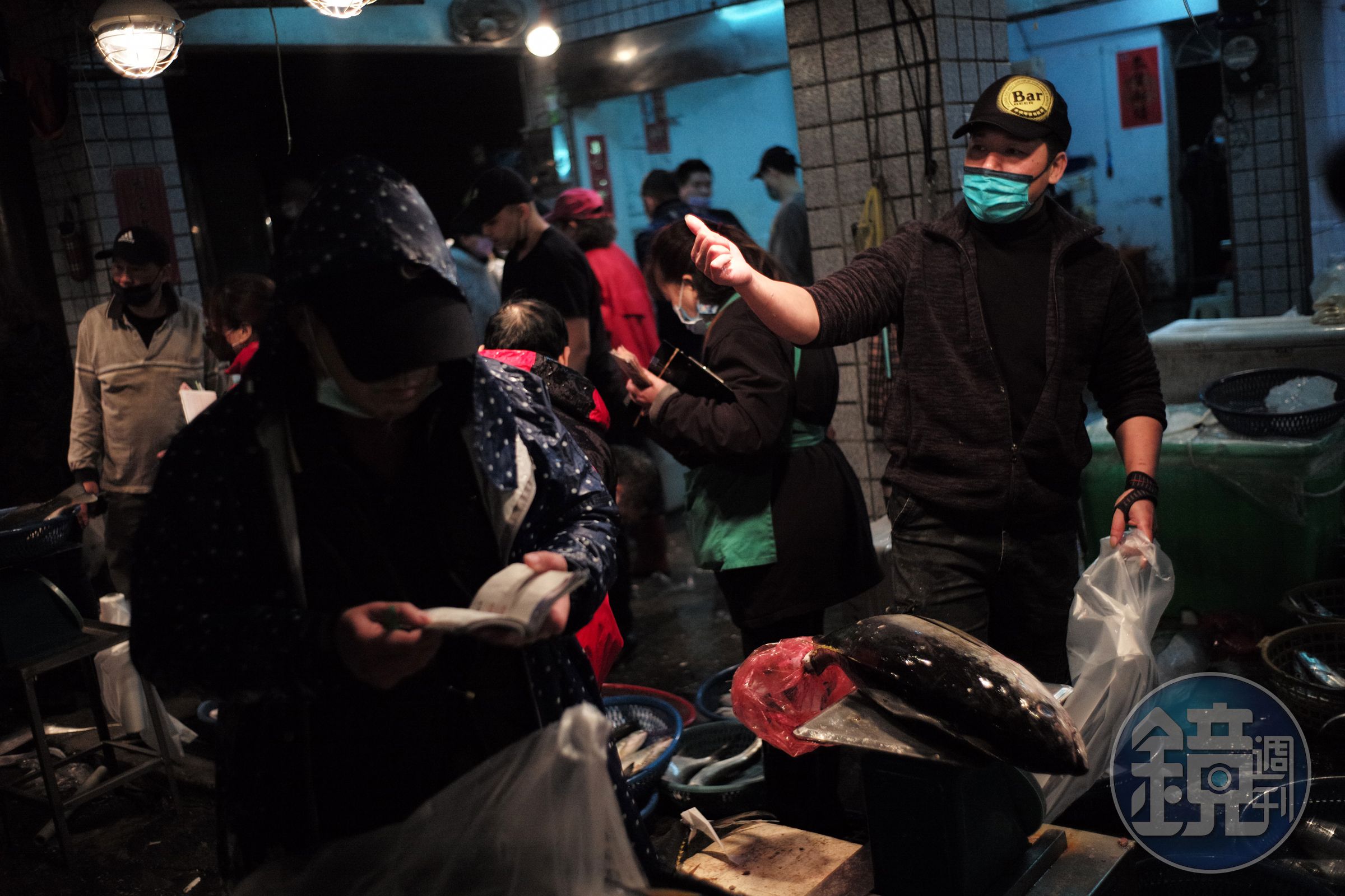 買家拿著記事本認真地聆聽著漁貨的價格。