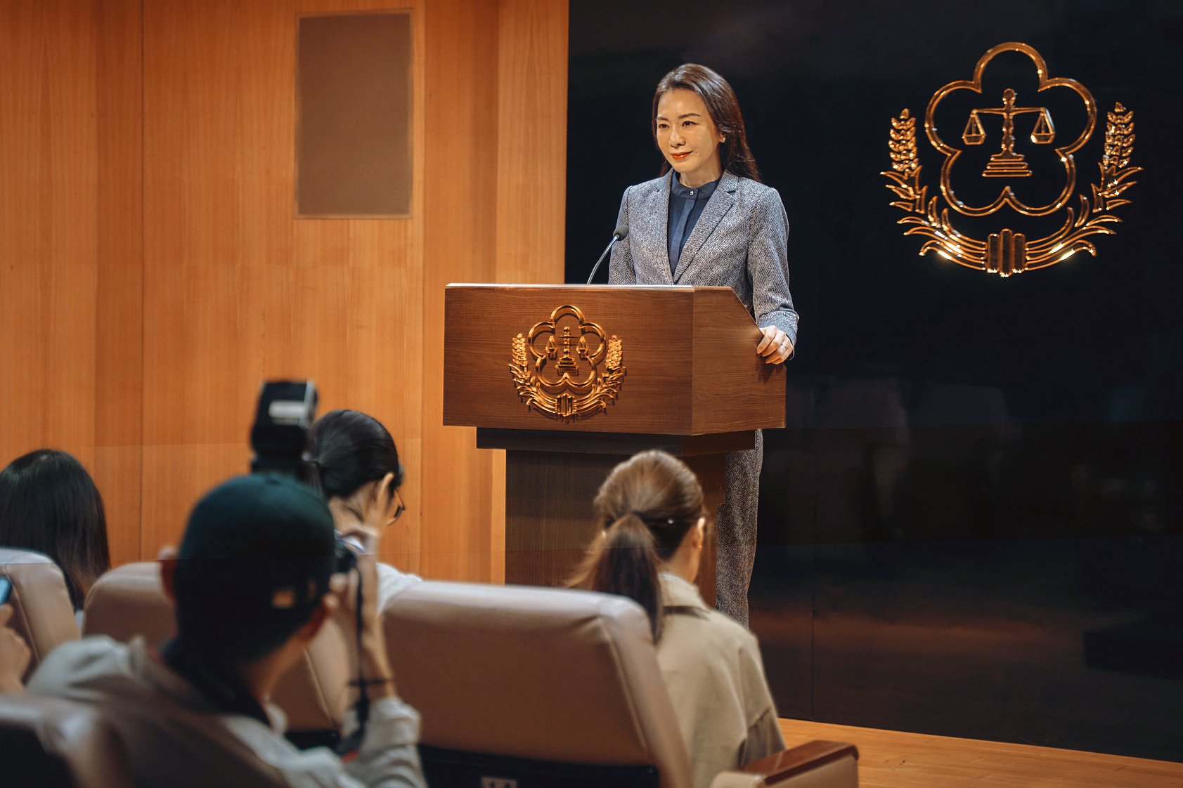 《八尺門的辯護人》法務部長陳令秋（潘儀君飾演）主持法務部記者會。（鏡文學提供）