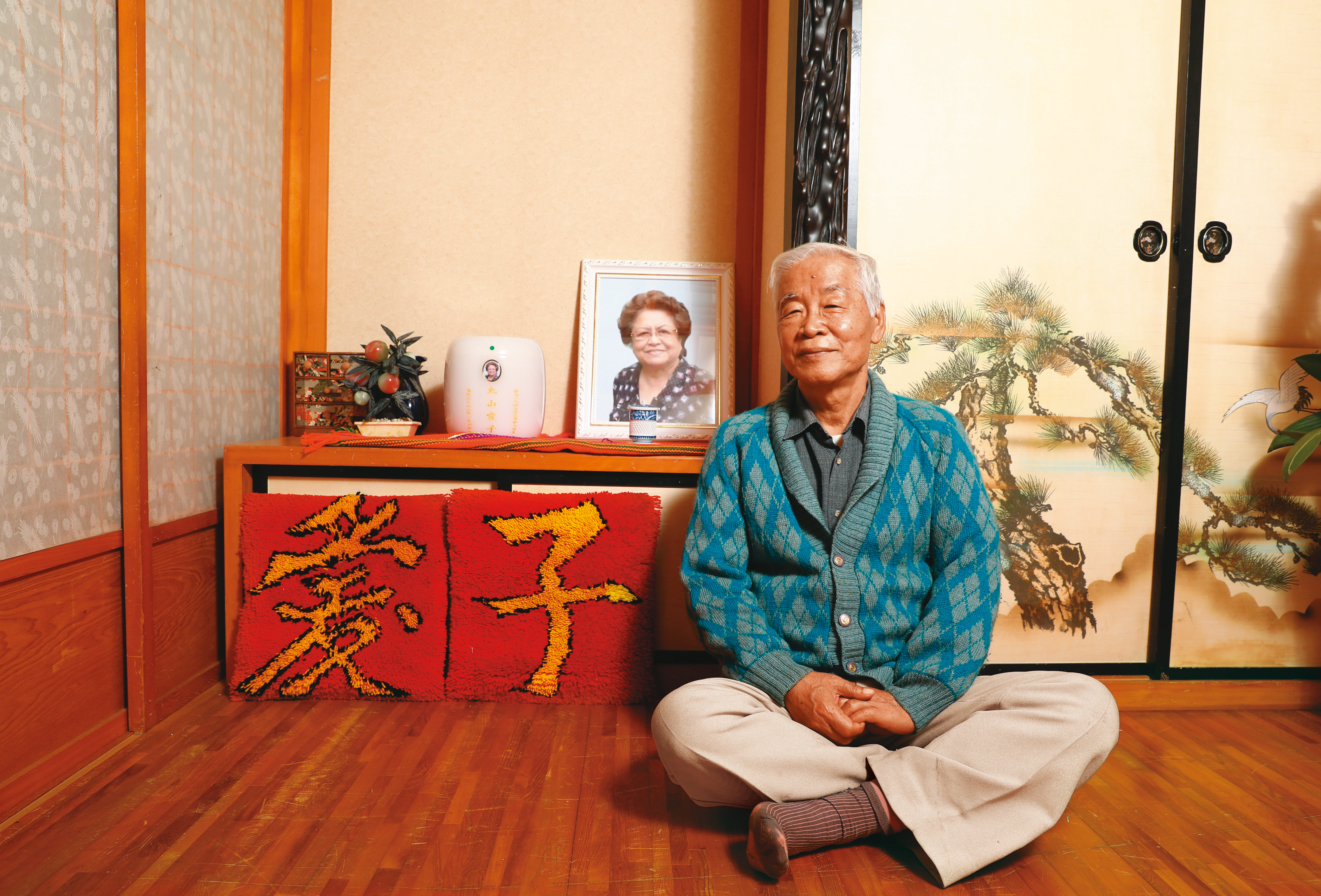 田春綢逝世後，骨灰安放花蓮家中，這天丸山特地穿上田春綢為他編織的毛衣，與太太合影。
