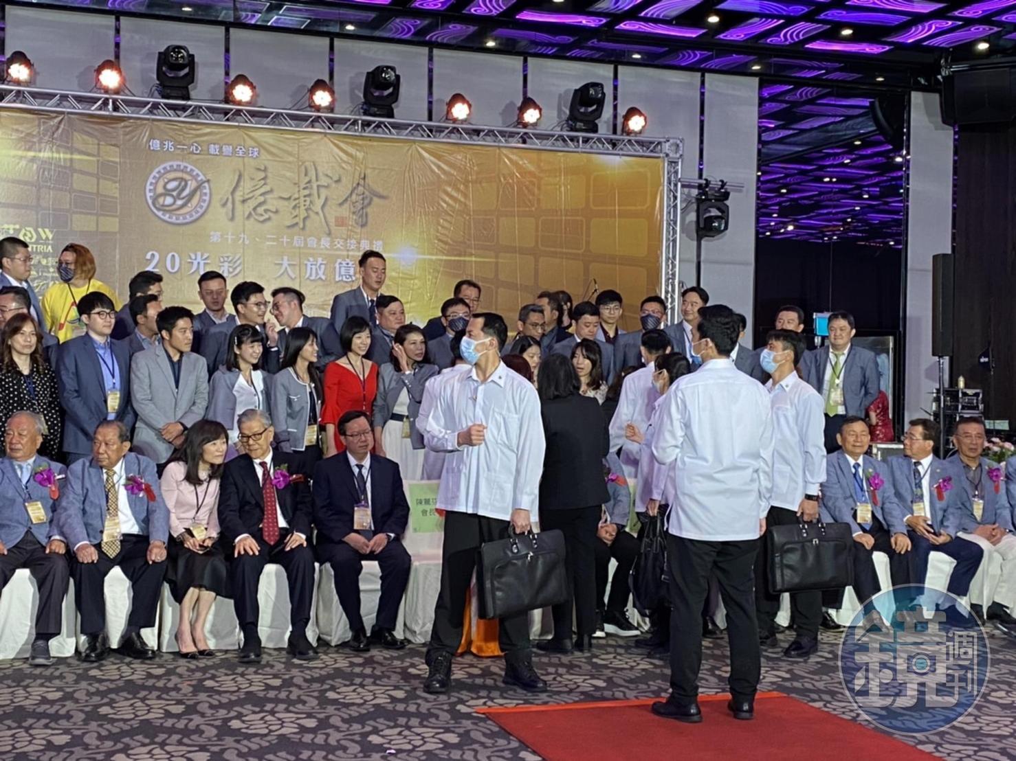 總統蔡英文起身與企業家寒暄，等待拍照就定位空檔，維安小組排成人牆。