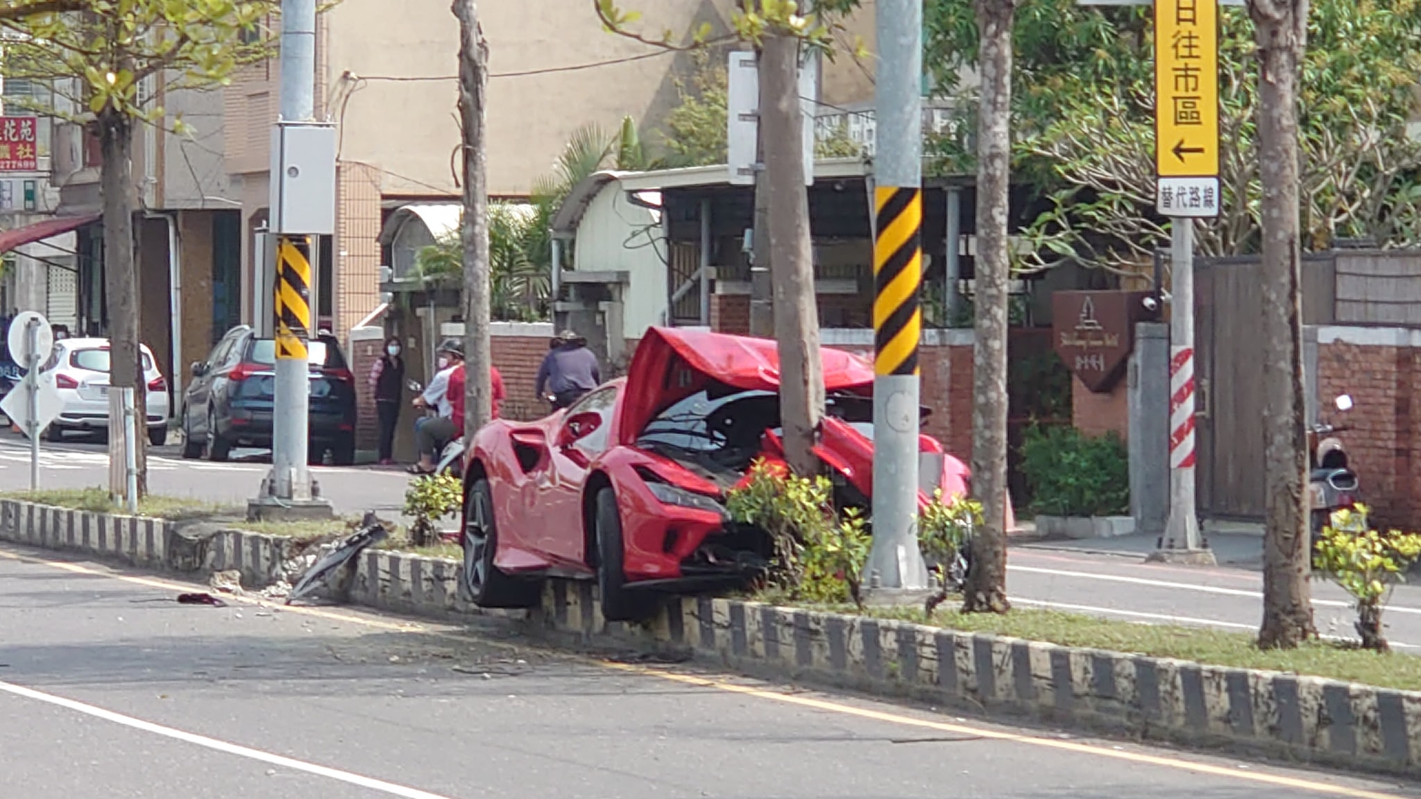一名網友今在前往台南安平老街的路上，目擊一輛紅色法拉利衝上分隔島。（翻攝自爆廢公社公開版）