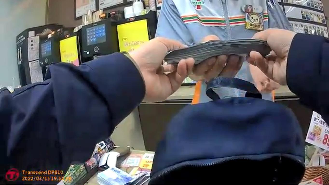 警員把撿到的鈔票拿到超商清點。(翻攝畫面)