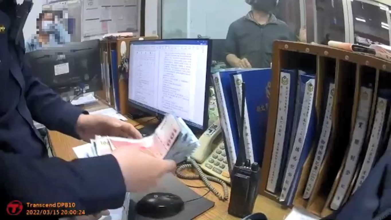 警員把現金放在值班檯等候失主。(翻攝畫面)