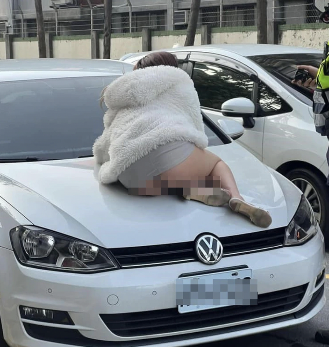 該名女子不顧自己是否走光,就這樣趴在引擎蓋上。(翻攝自爆廢公社)