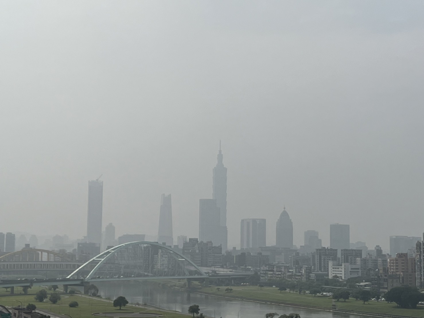 台北的天空儘管有太陽照拂，但霧濛濛的仍無法將台北101看清楚。