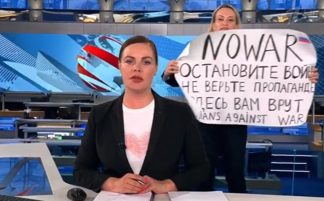 俄羅斯國營電視台新聞編輯奧斯雅尼可娃在新聞直播時，手持反戰標語闖入攝影棚高呼口號反戰。（翻攝推特）