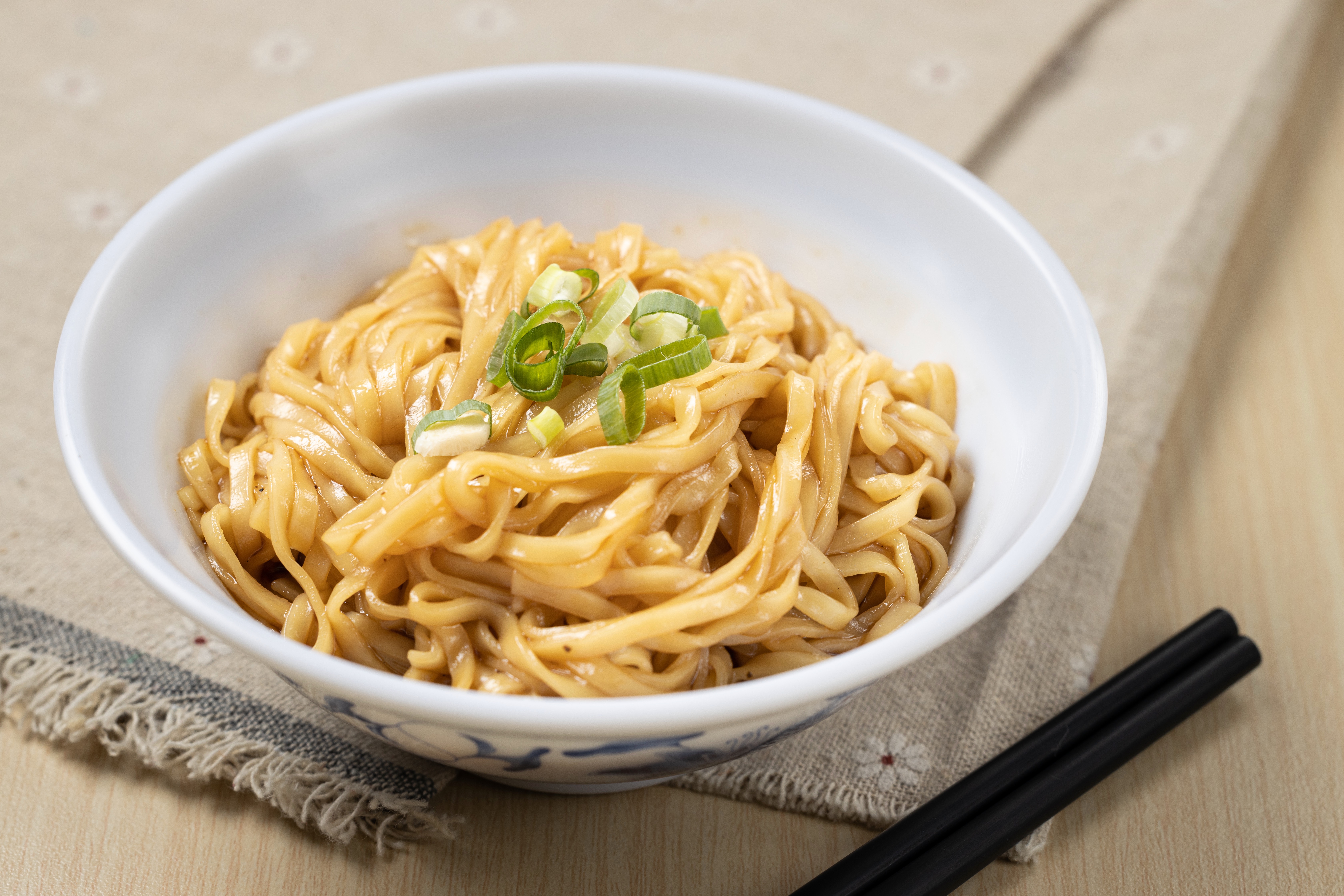 拌勻川味調料的「瓊芳撚麵」，選用扁形雞蛋麵，能感受到麵體的Q勁。（55元／碗）