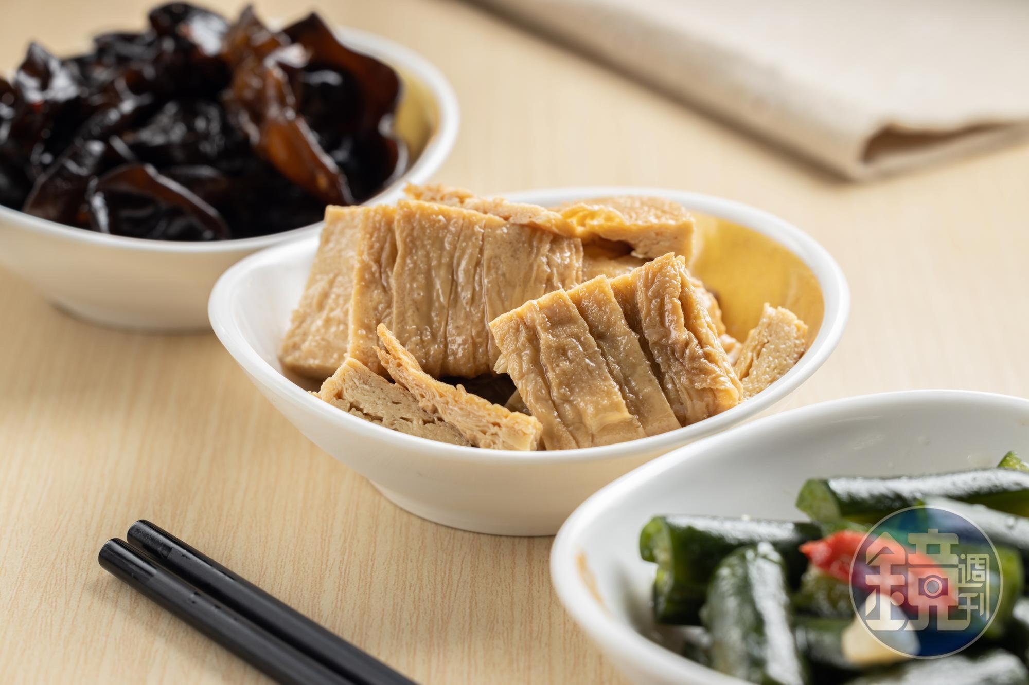 「麻油豆包」（中，58元／份）採用「本家生機」的非基改豆包，淋上純黑芝麻油提香；「湯燒川耳」（左）和「涼拌黃瓜」（右），在製作上也很講究。（皆35元／份）