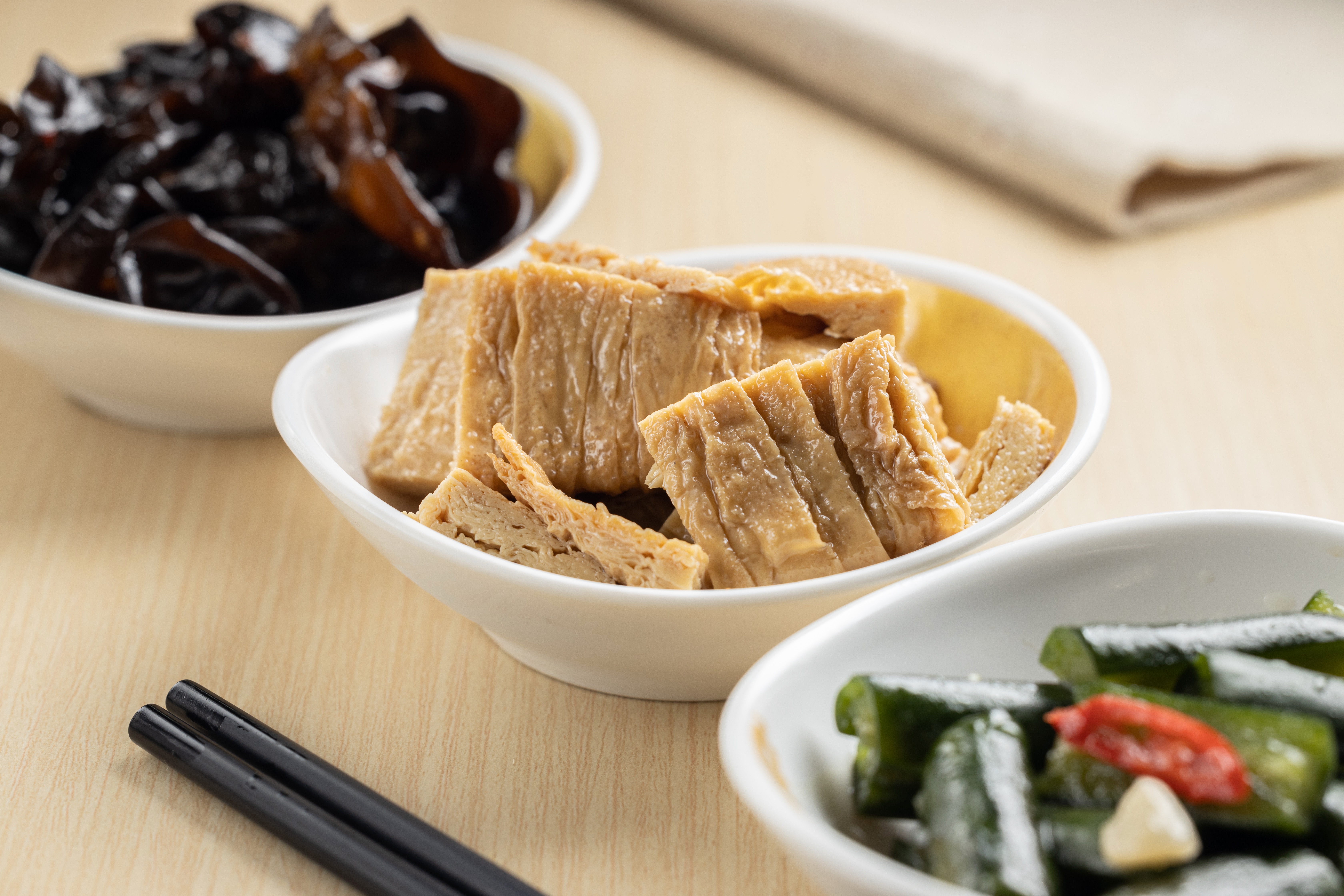 「麻油豆包」（中，58元／份）採用「本家生機」的非基改豆包，淋上純黑芝麻油提香；「湯燒川耳」（左）和「涼拌黃瓜」（右），在製作上也很講究。（皆35元／份）