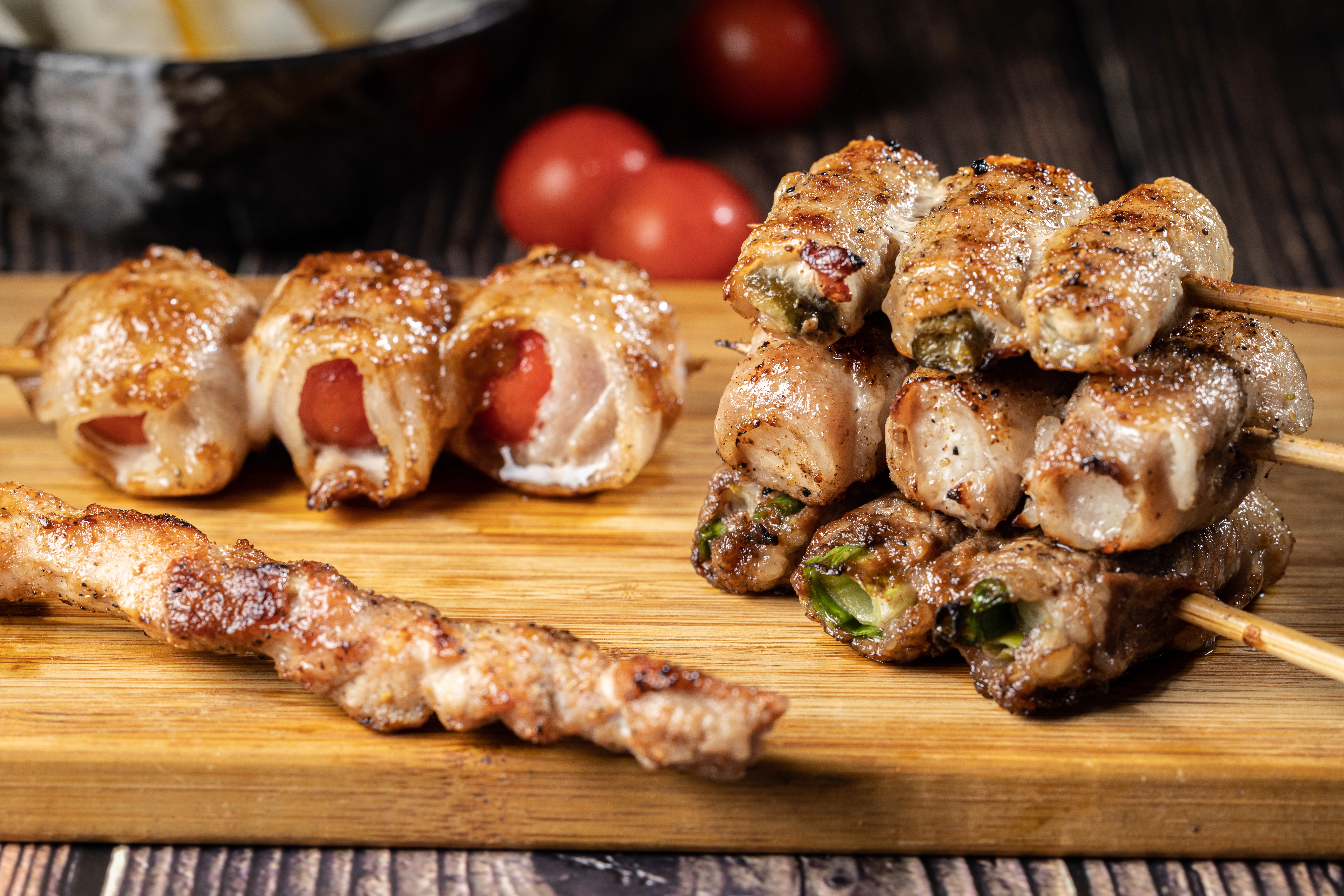 我喜歡包著漬物、蔬果的「剝皮辣椒豬五花」（右上至下）「柚香蘿蔔豬肉捲」「三星蔥牛肉捲」和「番茄豬五花」（左後），層次豐富不膩。撒上特調香料的「孜然羊肉串」（左下），表現也很優異。（50～60元／串）