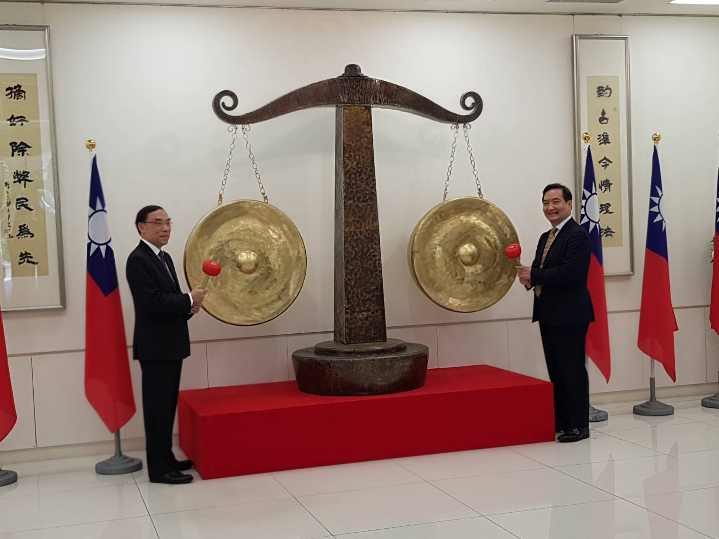 行政院政務委員羅秉成(右)及法務部長蔡清祥(左)主持司法之秤捐贈儀式,2人共同敲響銅秤,代表發出正義之聲。