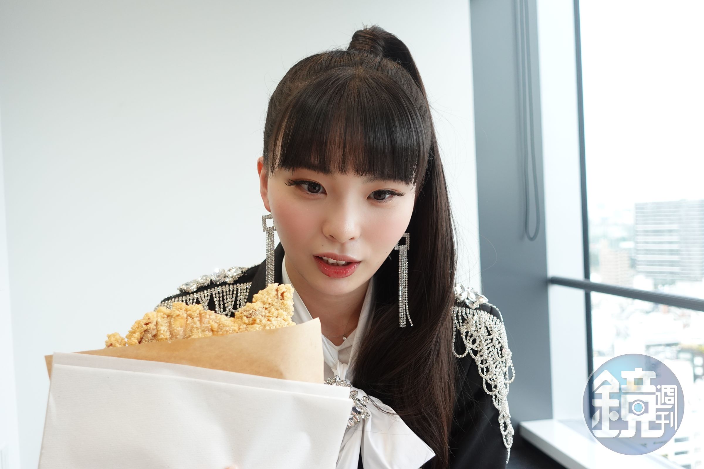 川口Yurina拿著台灣味雞排在鏡頭前跟自己的臉比大小，超級可愛。（環球唱片提供）