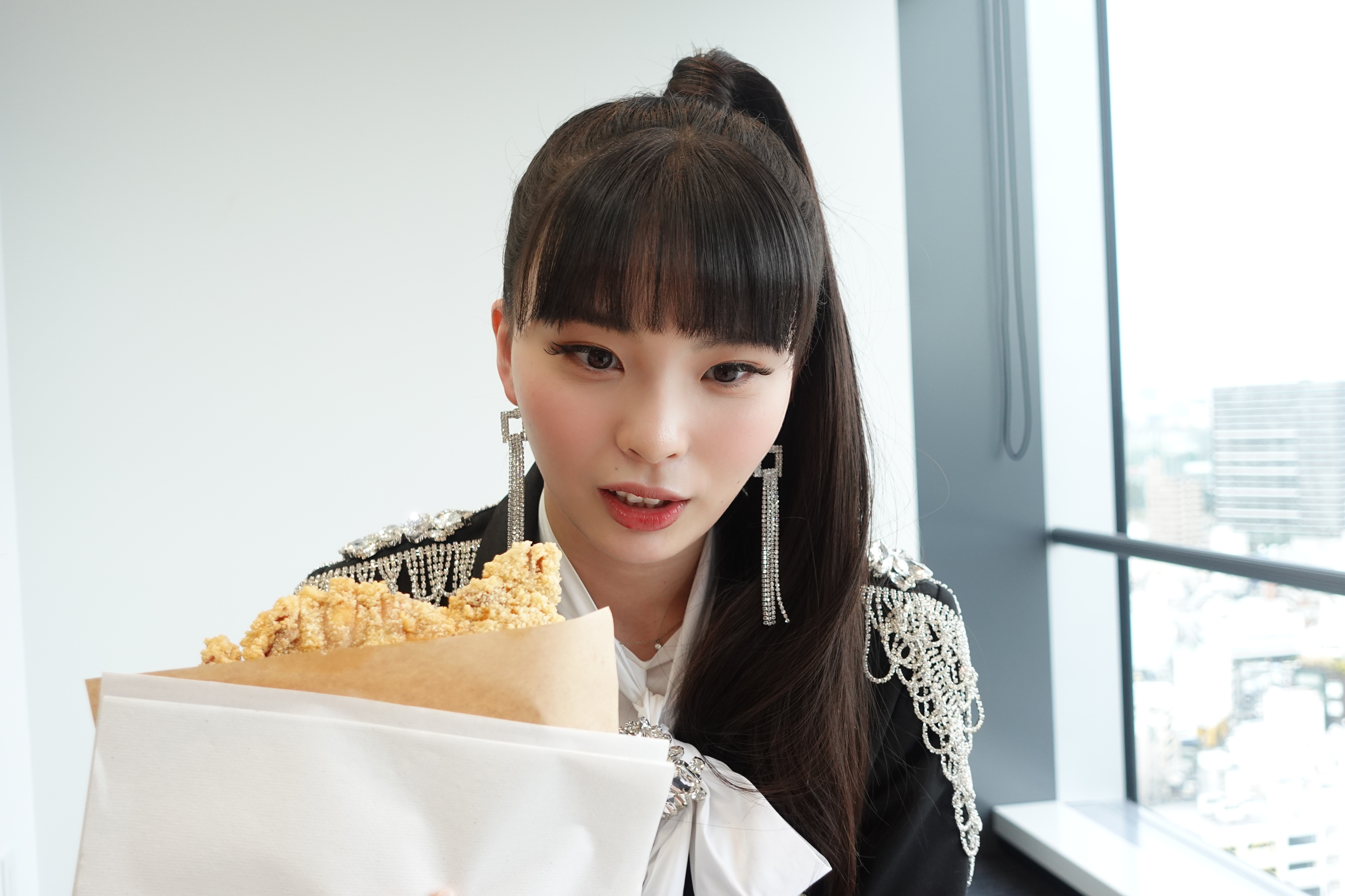 川口Yurina拿著台灣味雞排在鏡頭前跟自己的臉比大小，超級可愛。（環球唱片提供）