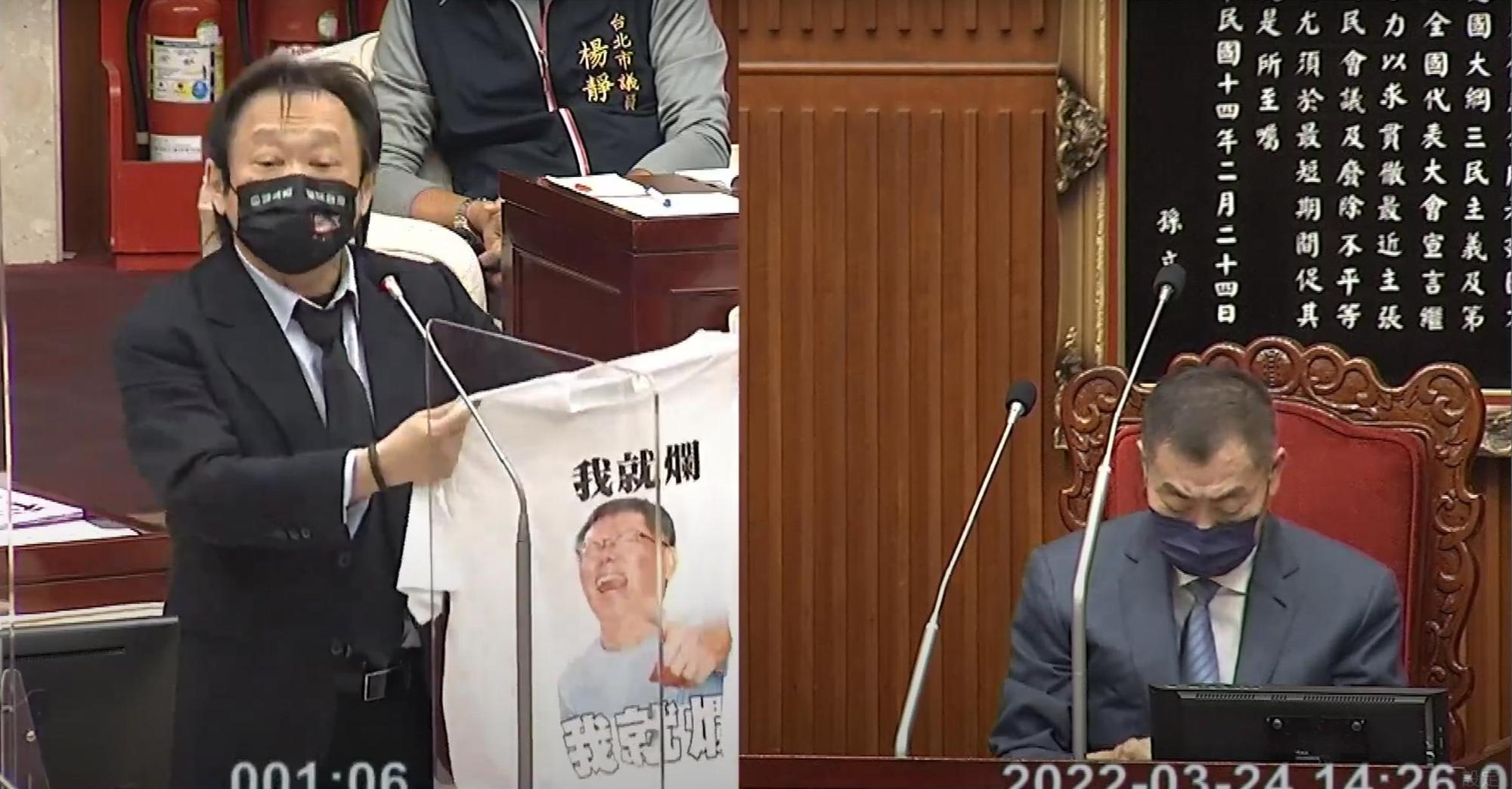 市議員王世堅今在議會中,批評柯文哲滿意度最低、民調墊底,他隨後還送上2件印有柯頭像的「我就爛」T恤。(翻攝自柯文哲YouTube頻道)