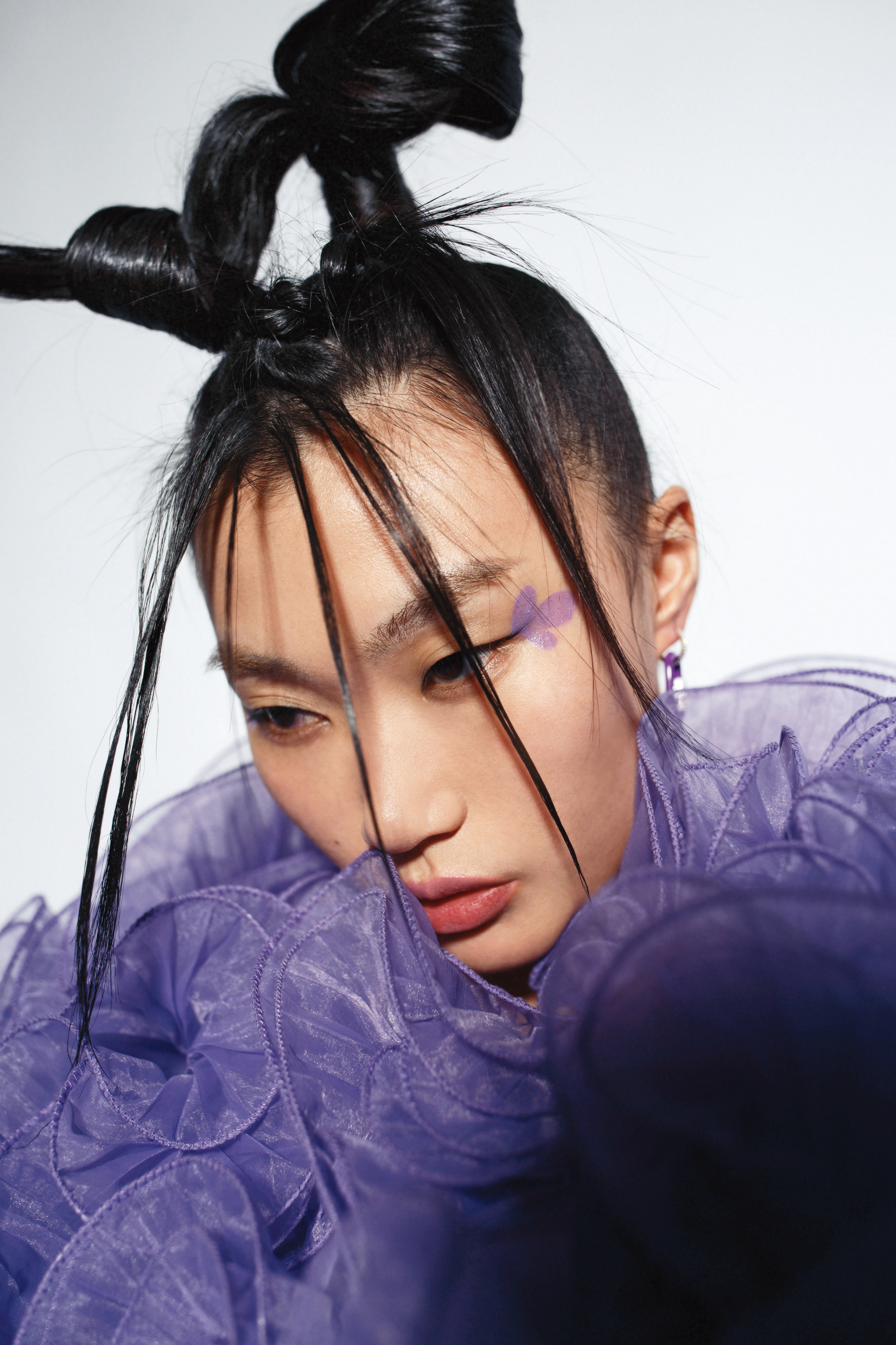 紫色荷葉邊外套NT$9,999 by Iris Apfel X H&M、紫色環扣耳環（單只）NT$4,200 by APM Monaco。