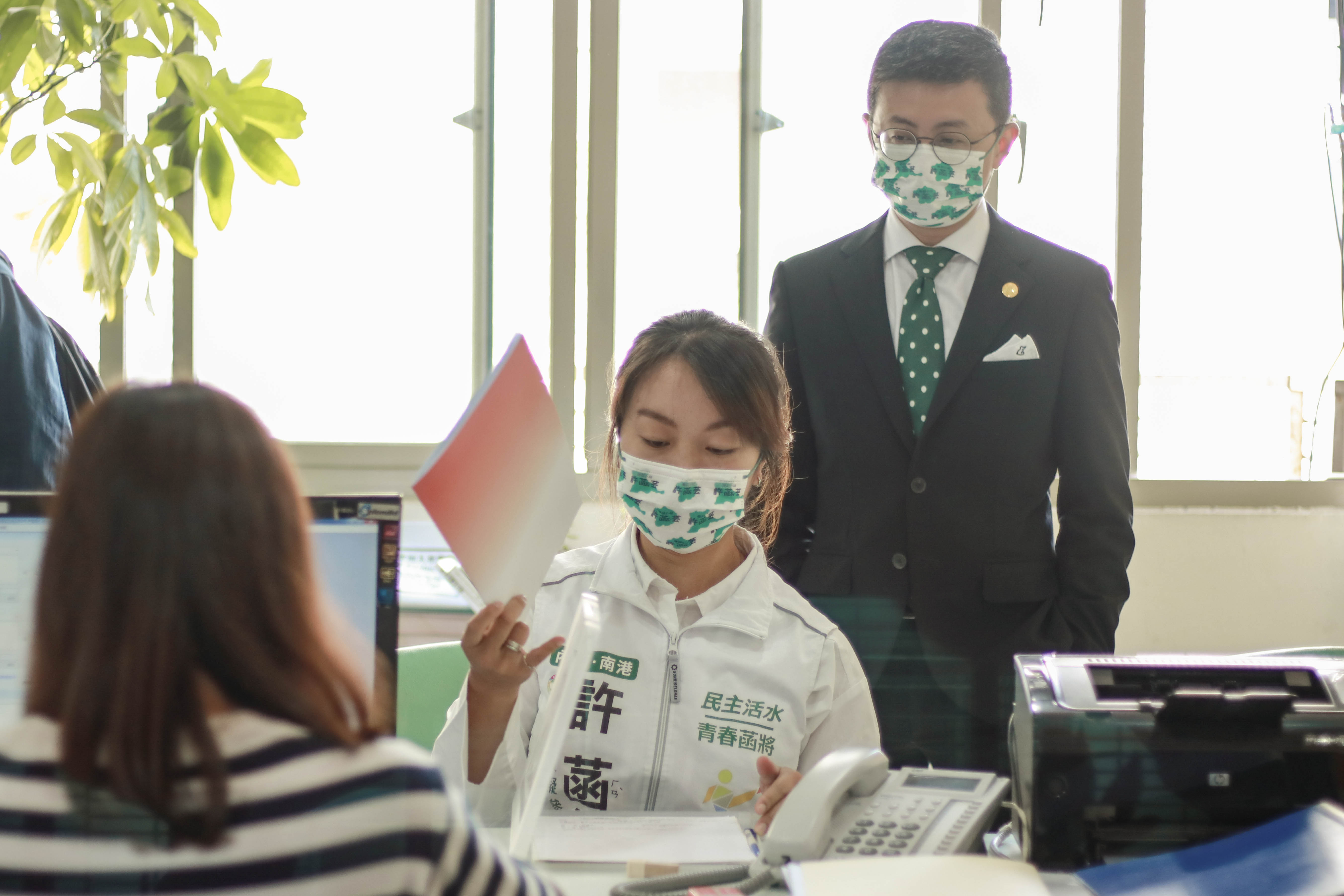 邱威傑（後）陪同自己的前辦公室主任許菡芸登記參加民進黨黨內初選。（謝孟羽提供）