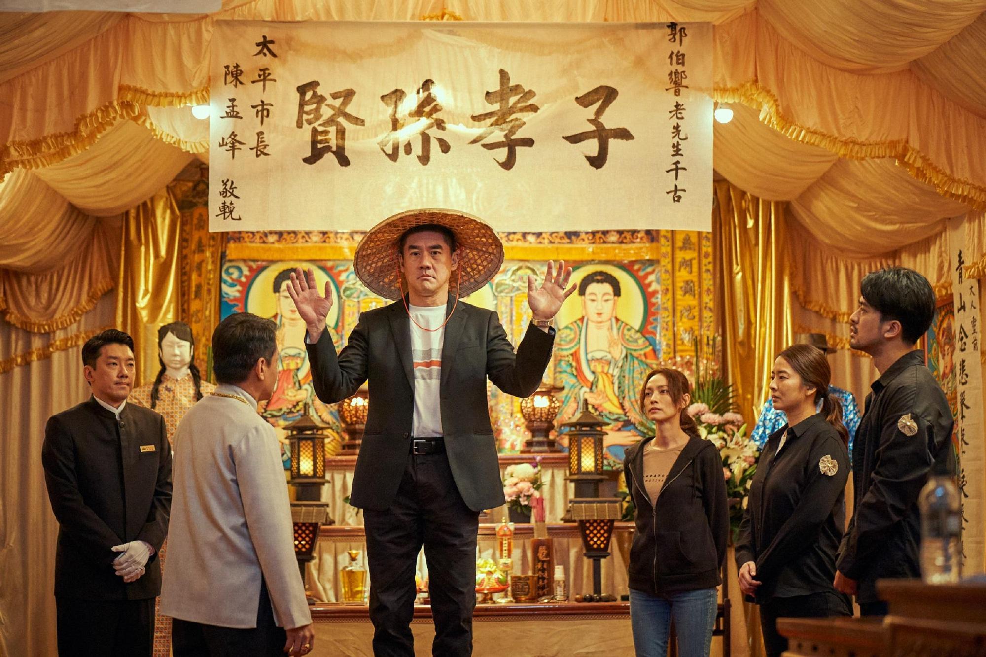 吳大維飾演國外回來的大哥,一家人在靈堂前的互動頗荒謬。(Catchaplay提供)