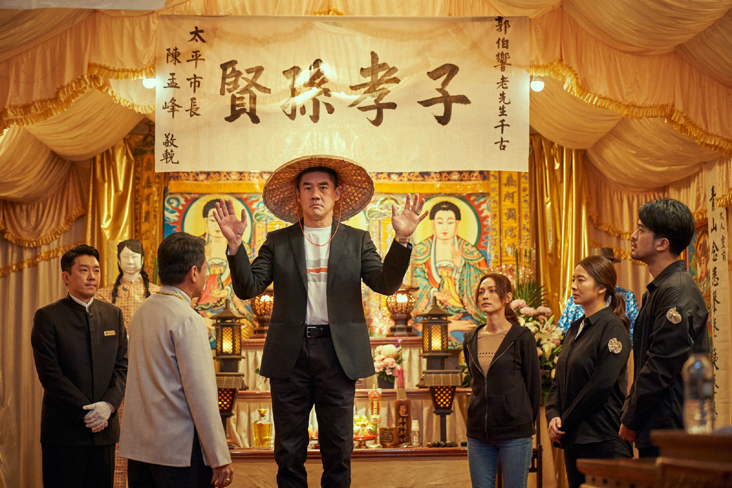 吳大維飾演國外回來的大哥，一家人在靈堂前的互動頗荒謬。（Catchaplay提供）