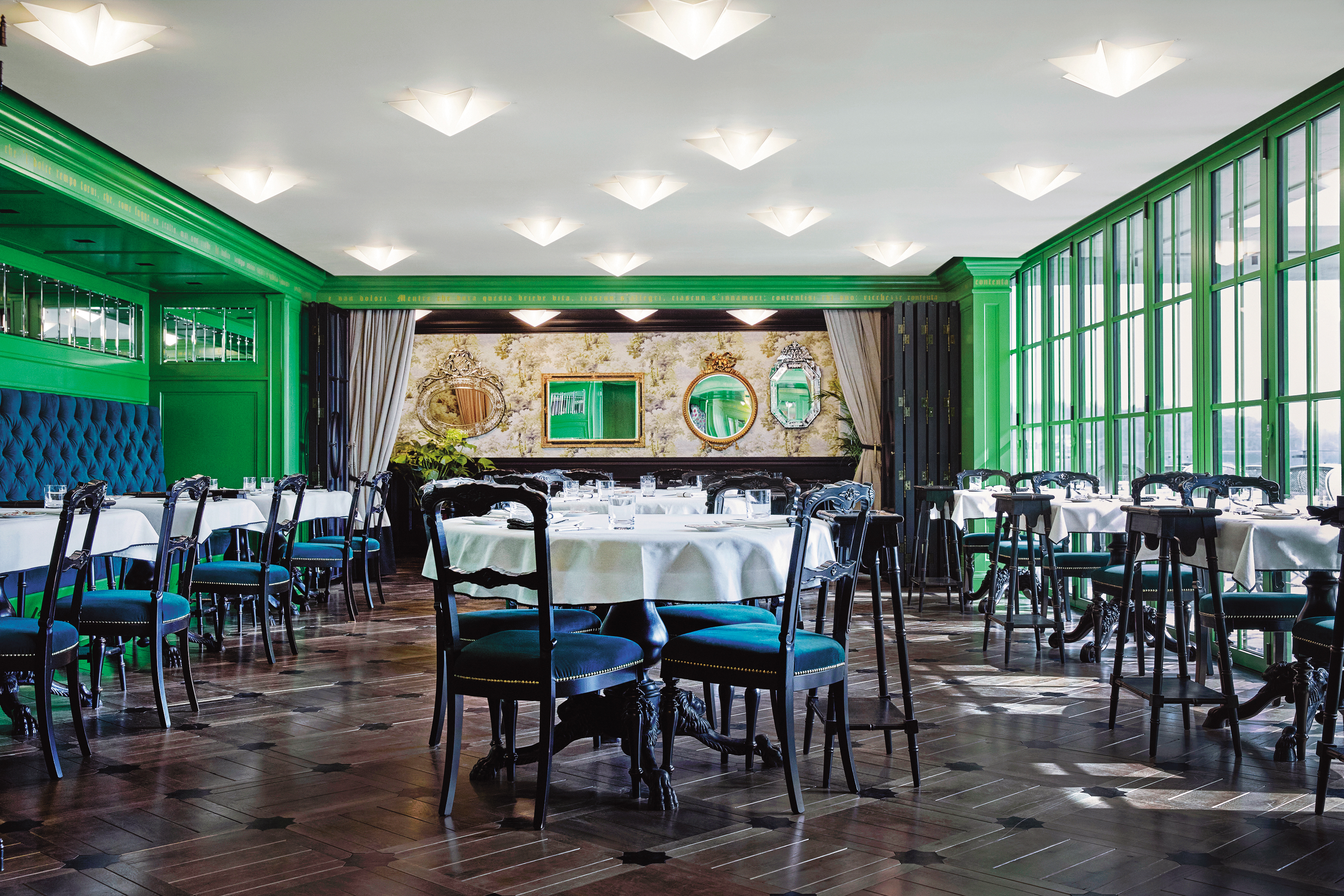一到Gucci Osteria da Massimo Bottura入口處，客人將會沉浸在充滿活力的綠色牆面中，店內從木製鑲板到露台的格魯吉亞酒吧露台門，皆喚起冬季花園的氛圍。