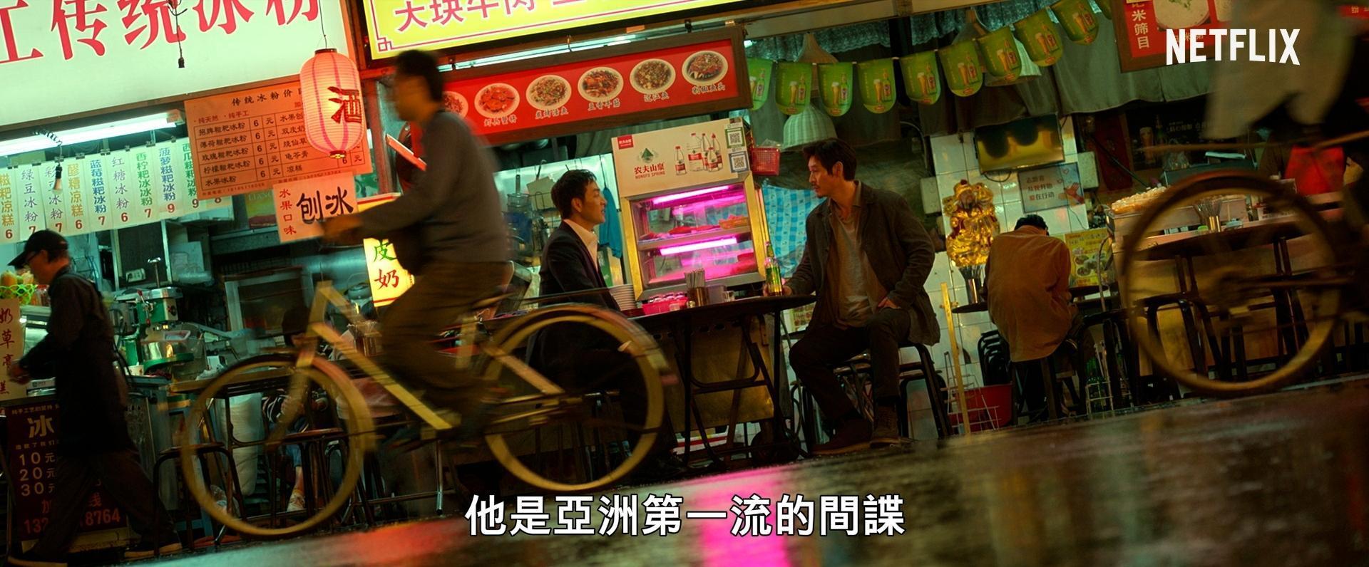 朴海秀（左）與薛景求坐在遼寧夜市對戲，不過因為劇情設定地點位於中國瀋陽，場景都被貼上了簡體字海報。（截圖自預告）