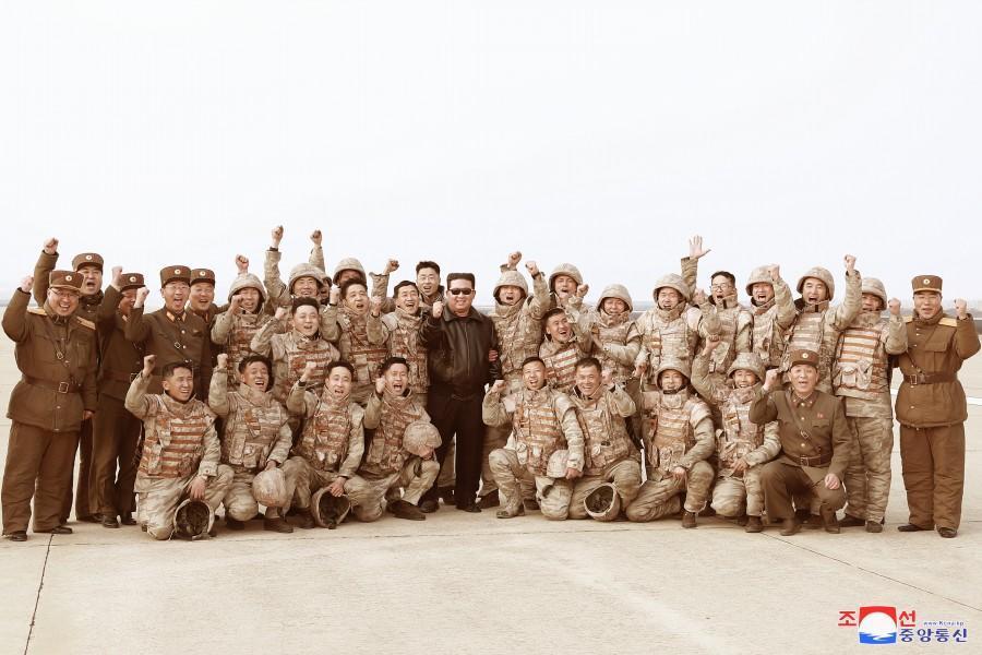 金正恩與穿著軍裝的軍人一起振臂開心合照,慶祝「火星-17」試射成功,簡直就神似韓劇《太陽的後裔》的劇照。(翻攝自朝中社)