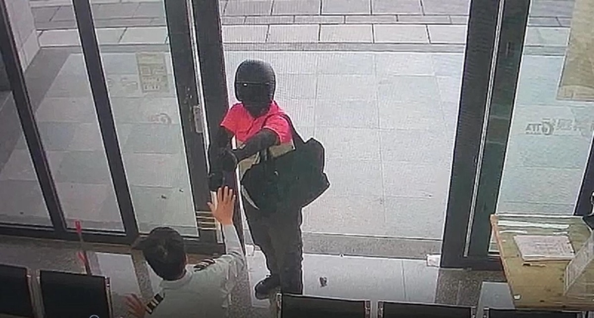 搶匪穿著外送員服裝闖高雄市三信銀行橋頭分行搶劫。 （翻攝畫面）