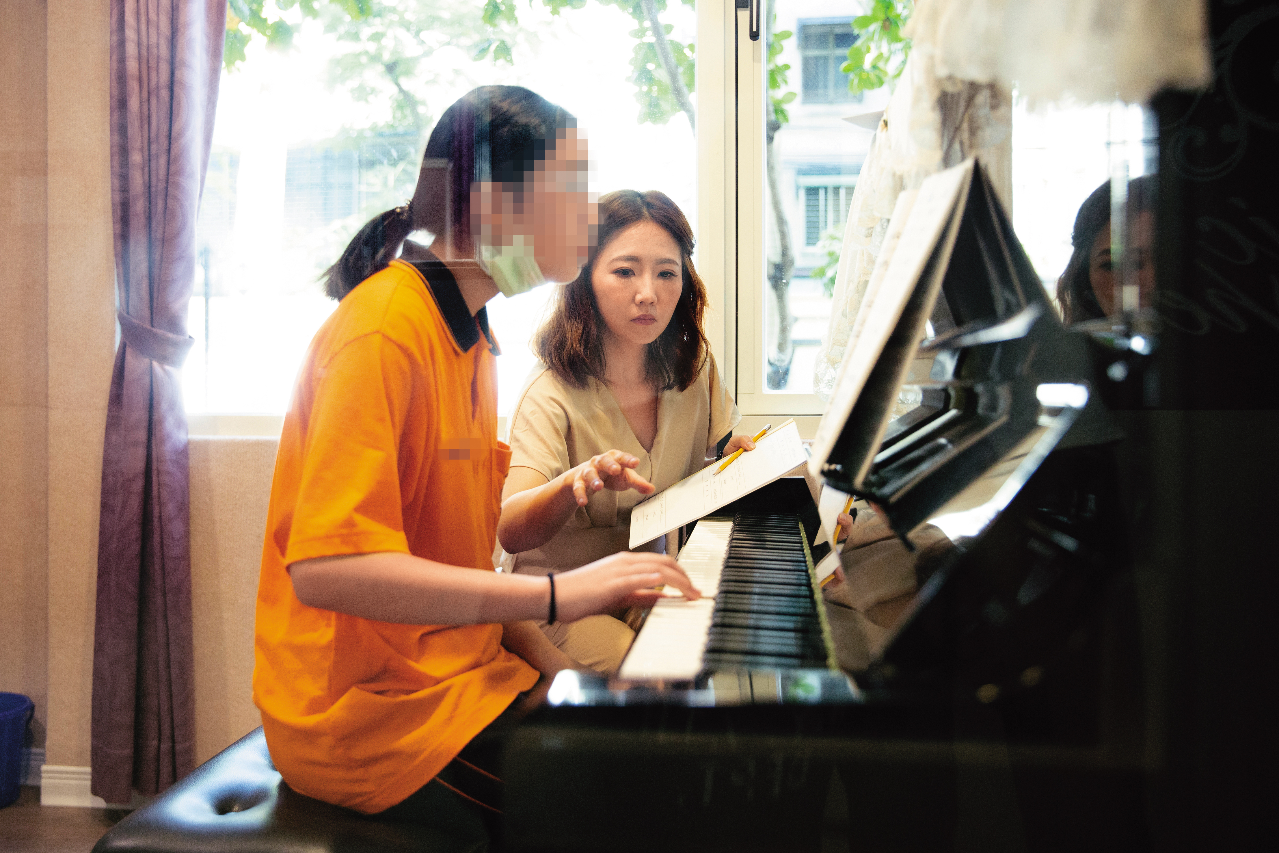 謝忻(右)曾是留英的音樂系碩士,也重返校園當音樂老師。