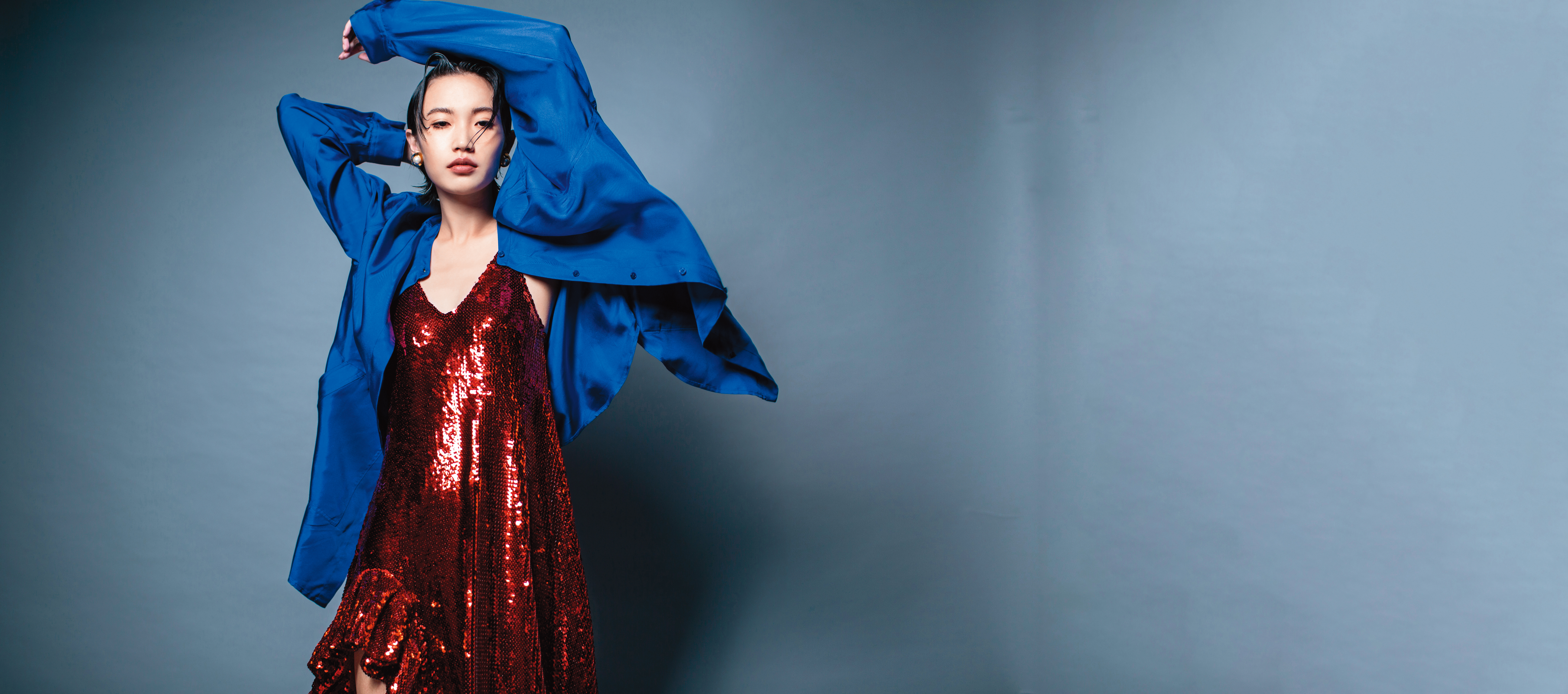 藍色緞面oversize襯衫 NT$19,100 by Longchamp／紅色亮片洋裝 NT$242,000 by LOEWE／珍珠耳環 NT$14,000 by MIU MIU 