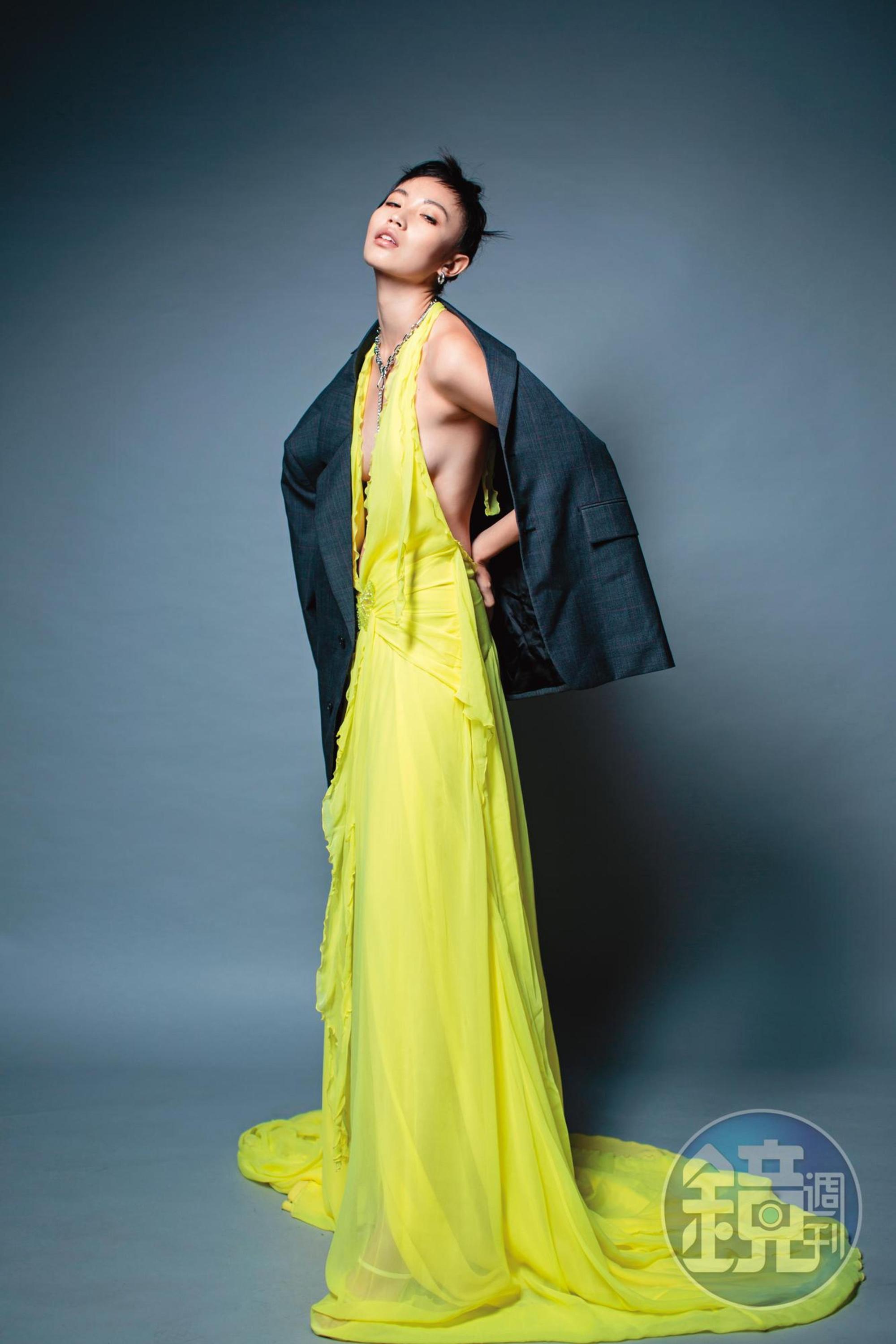 單排扣西裝外套 NT$125,000 by PRADA／黃色雪紡紗長洋裝 NT$97,800 by BLUMARINE／銀色耳環 價格店洽 by LOEWE／黑色愛心金屬項鍊 NT$1,499 by H&M