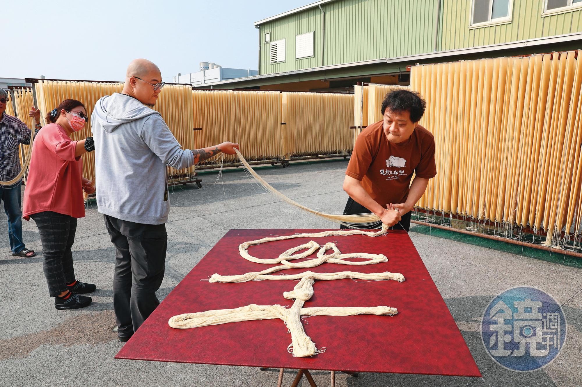 鄉親父老喜愛陳世憲（右）的作品。圖為陳世憲受邀至彰化麵線工廠，以麵線做複合媒材書法創作。
