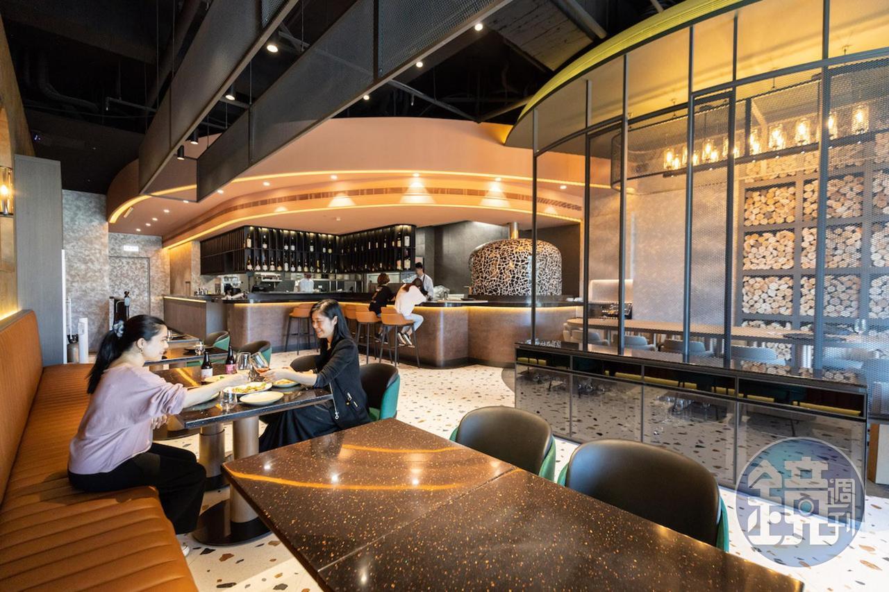 「LA ONE Pizza」的用餐空間，結合大理石、木面及皮革等建材元素，以直弧線條構築出現代感。
