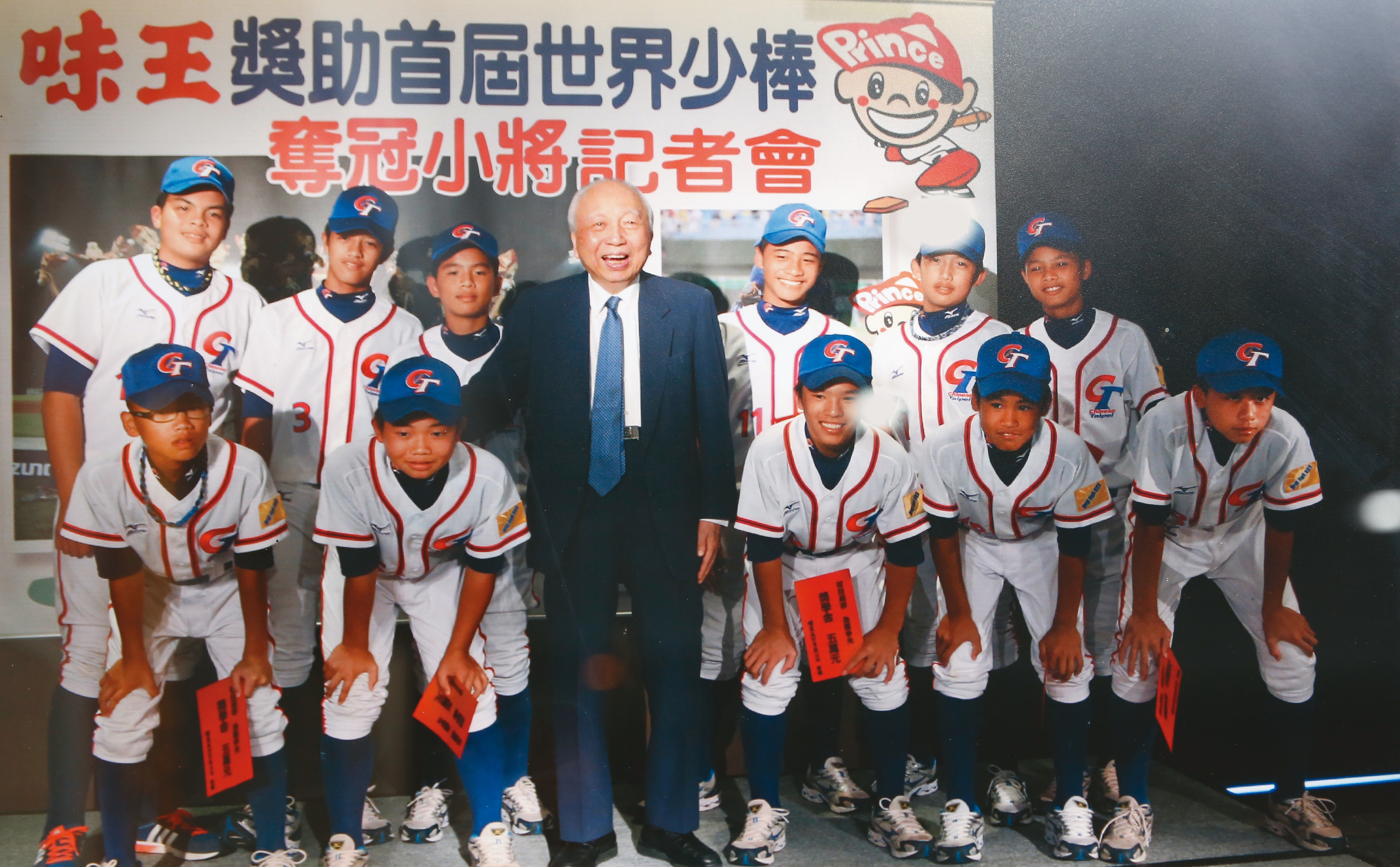 頴川建忠(中)旗下事業市值逾千億元,2011年曾以味王董事長名義,獎助第一屆IBAF世界少棒冠軍隊。(翻攝畫面)
