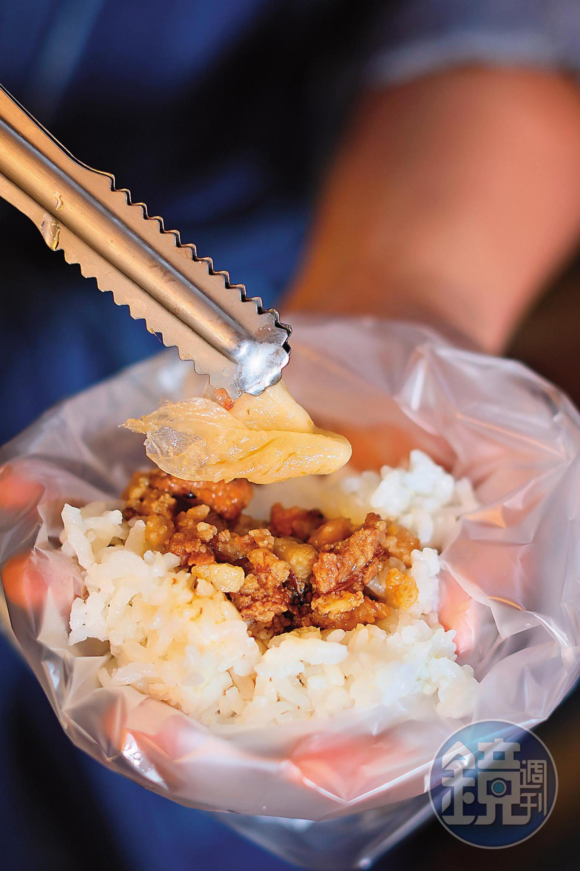 已是熟客的李政道，自己動手將「滷肉飯」（25元／份）與醬瓜一起包成飯糰。