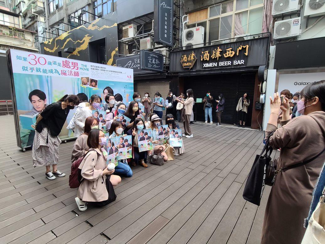 《電影版 櫻桃魔法》忠實粉絲一早6點就抵達電影院現場,熱情與海報合照。(車庫娛樂提供)