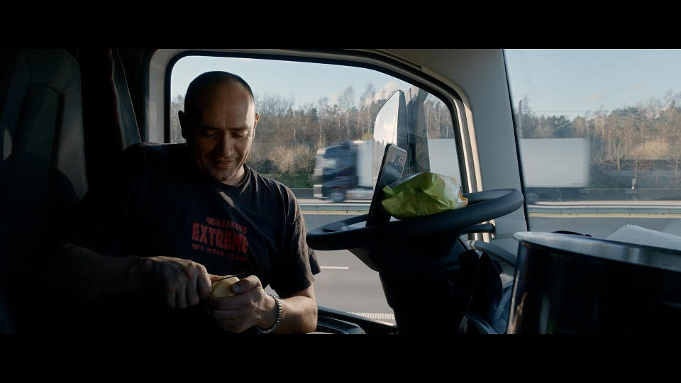 彼得多繹切夫在車上一邊削馬鈴薯準備煮食、一邊與家人手機視訊。(公視提供)