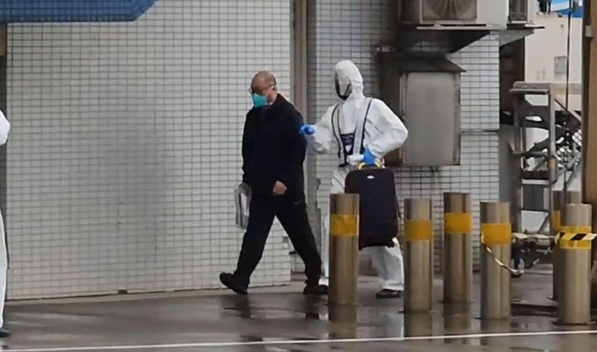 李明哲下機後，神情鎮定且輕鬆的跟著防疫人員指引。（桃園機場記者聯誼會提供）