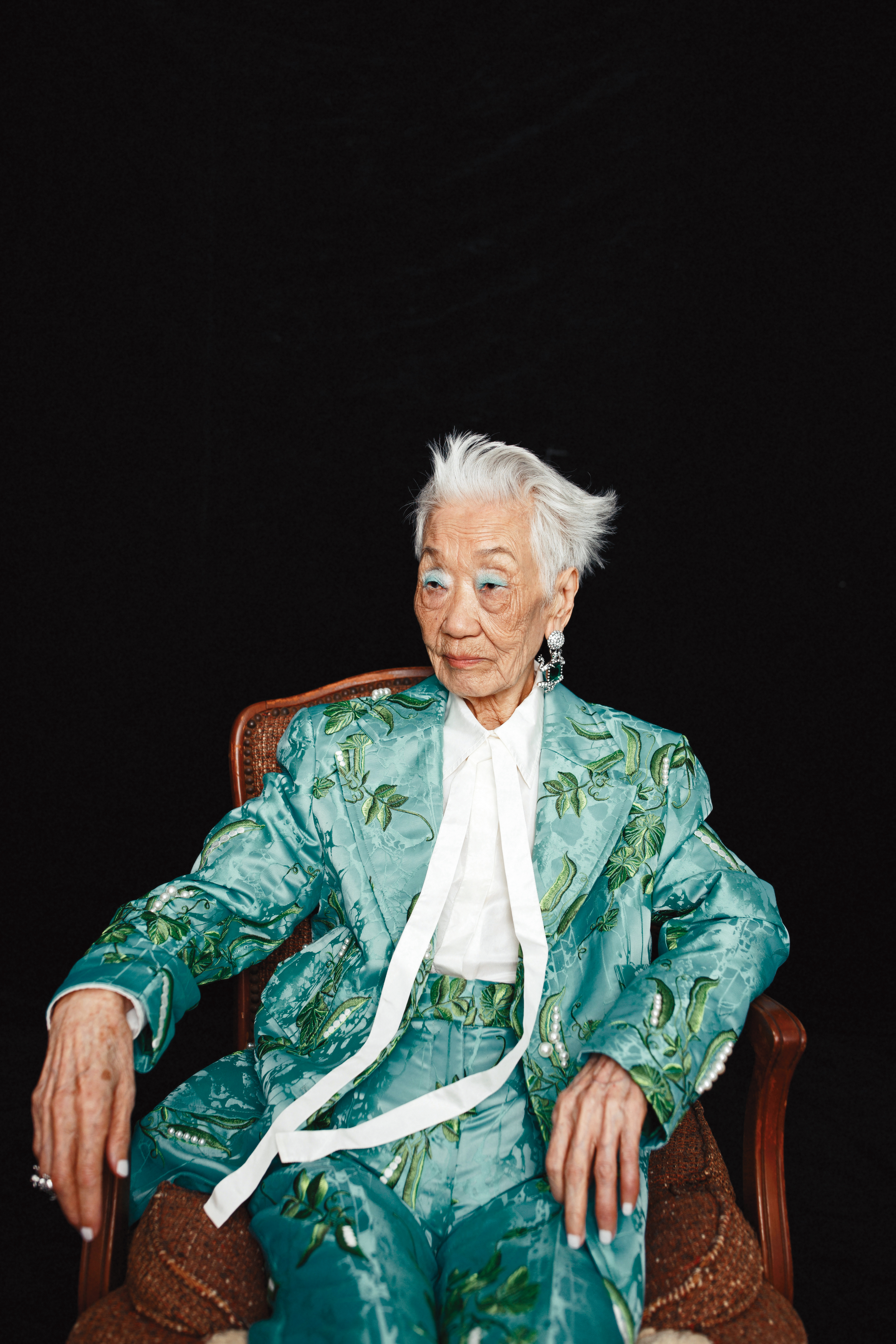 緹花平織貼花西裝外套，NT$4,999，by Iris Apfel X H&M；白色襯衫，價格店洽，by VALENTINO；緹花平織貼花西裝褲，NT$3,499，by Iris Apfel X H&M；青蛙水鑽夾式耳環，NT$1,499，by Iris Apfel X H&M；綠色寶石青蛙戒指 ，NT$2,499，by Iris Apfel X H&M。