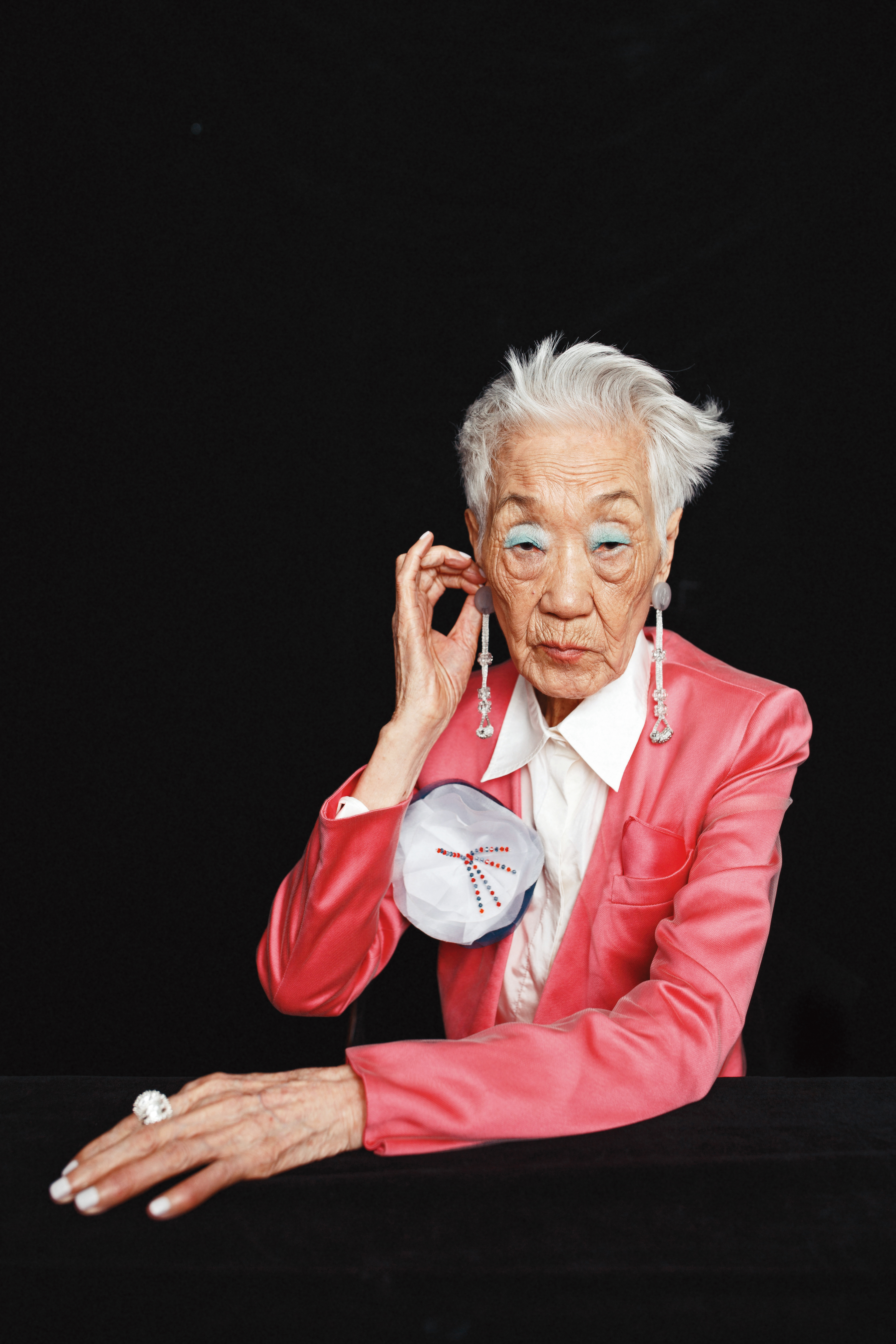 桃紅色附胸花紗面西裝外套，NT$146,800，by Giorgio Armani；白色襯衫，價格店洽，by VALENTINO；銀色繩結耳環，價格店洽，by Giorgio Armani；Fern純銀立體蕨葉鋯石戒指，NT$25,600，by BOTTEGA VENETA。