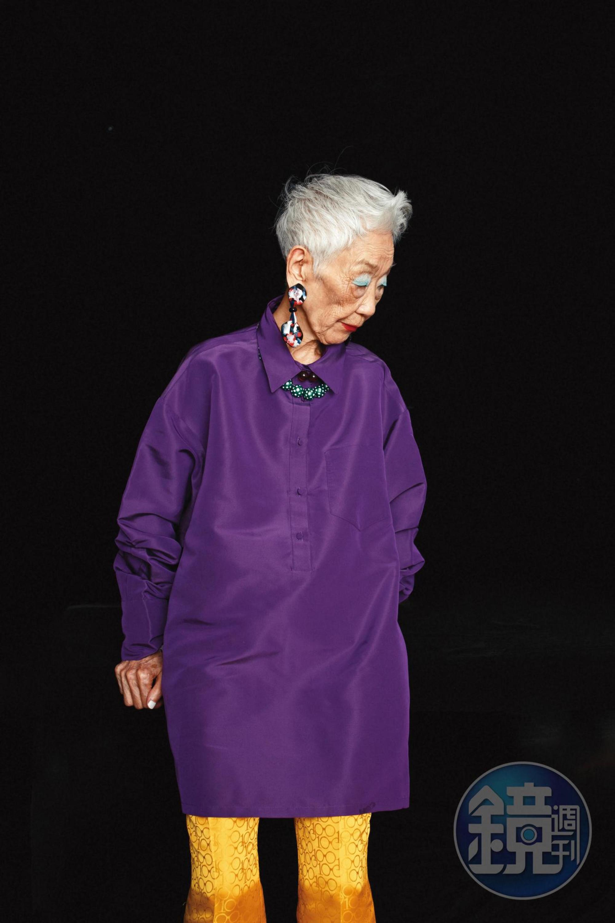 紫色寬版襯衫，價格店洽，by VALENTINO；黃色緹花長褲，NT$2,999，by Iris Apfel X H&M；不規則印花耳環，價格店洽，by Giorgio Armani；雙色珠珠項鍊，NT$1,999，by Iris Apfel X H&M。