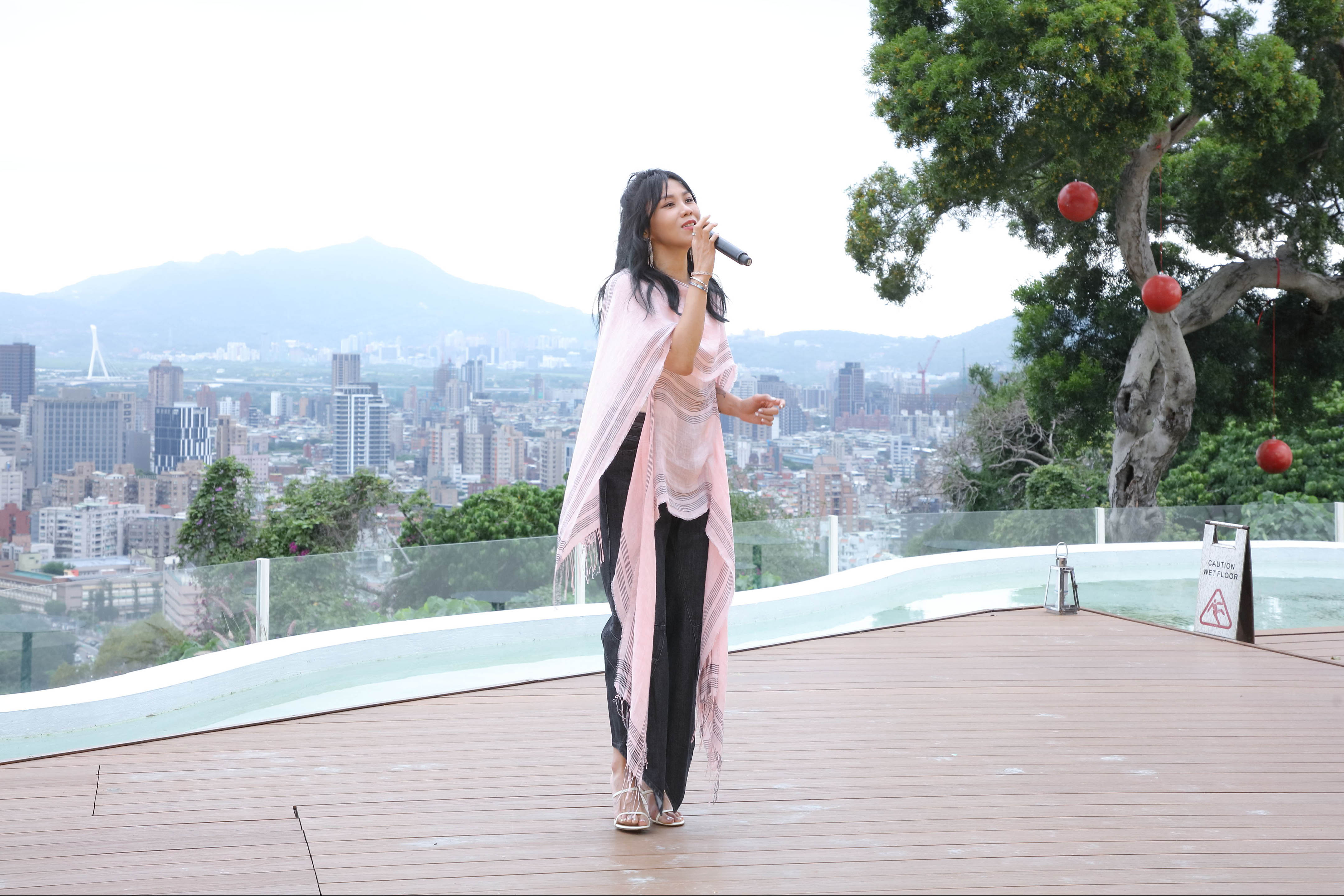 蔡健雅擔任LOEWE年度Paula’s Ibiza系列上市的表演嘉賓，身穿該系列的她，在陽明山上開唱。Paula’s Ibiza圍巾式上衣 NT $39,000、LOGO白色背心 NT$12,000、黑色不規則剪裁造型牛仔褲 NT$30,000、白色小山羊皮指甲油造型高跟涼鞋 NT$ 36,000 LOEWE。（LOEWE提供）