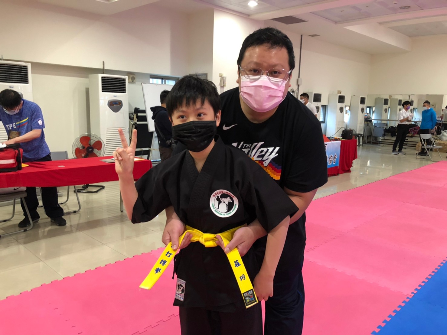 北市理事長蔡豐穗幫小選手整理衣裝。（北市武術散打搏擊協會提供）