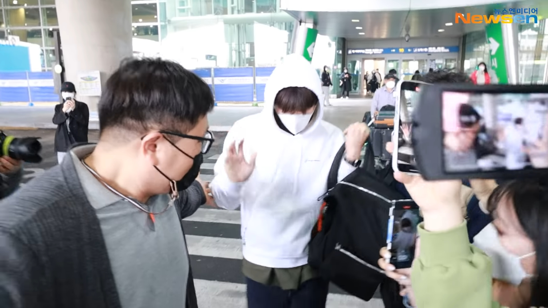 金宣虎雖低著頭,但看到大批媒體仍不時揮手致意。(翻攝自Newsen)