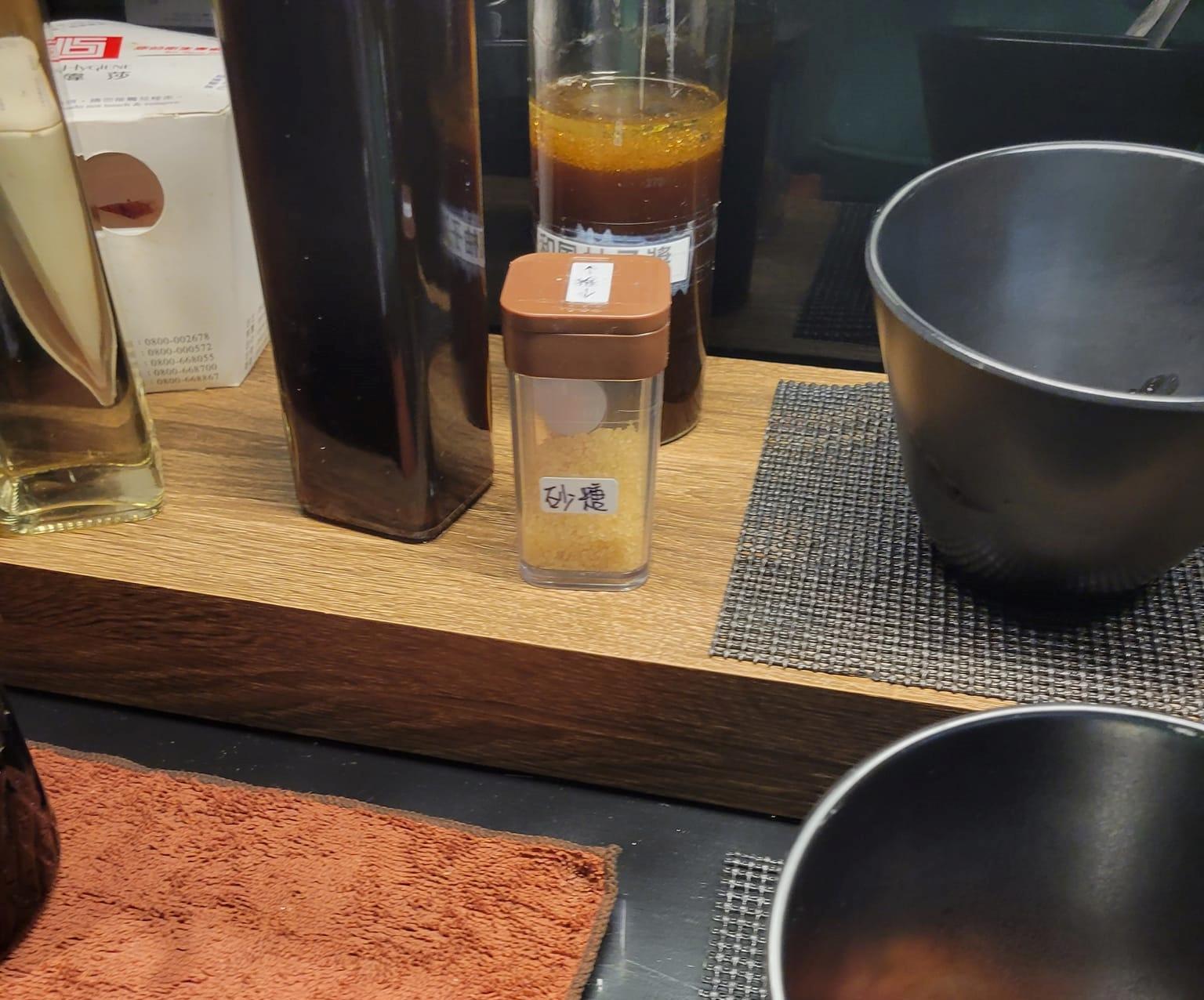 一名網友提出不解,為何火鍋店醬料區會放置砂糖。(翻攝自爆廢公社臉書)