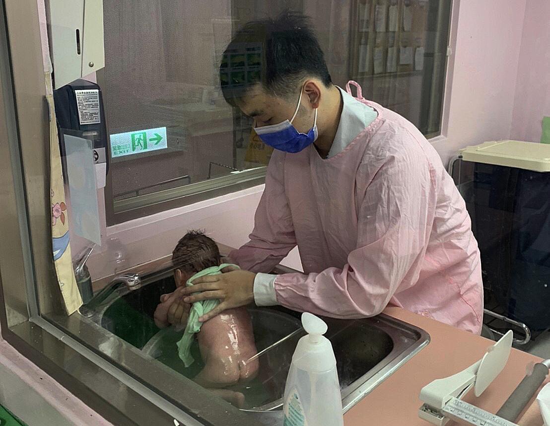 張庭維幫新生兒洗澡。(移民署提供)
