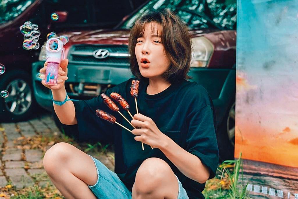 蔡淑臻手拿四支烤香腸，這張照片有「細八啦」（十八骰仔）的聲音。（公視提供）