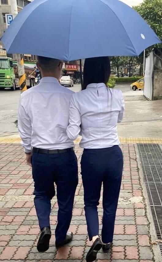 郭女與周男十分高調，甚至手挽著手同撐一把傘。（讀者提供）