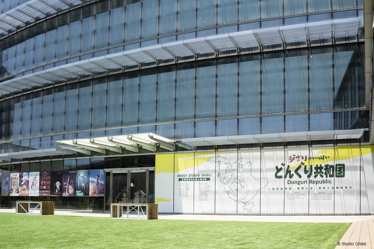 全系列的吉卜力工作室日版電影海報，展示於店鋪外空中花園的玻璃帷幕，歡迎粉絲合影留念。（© Studio Ghibli）